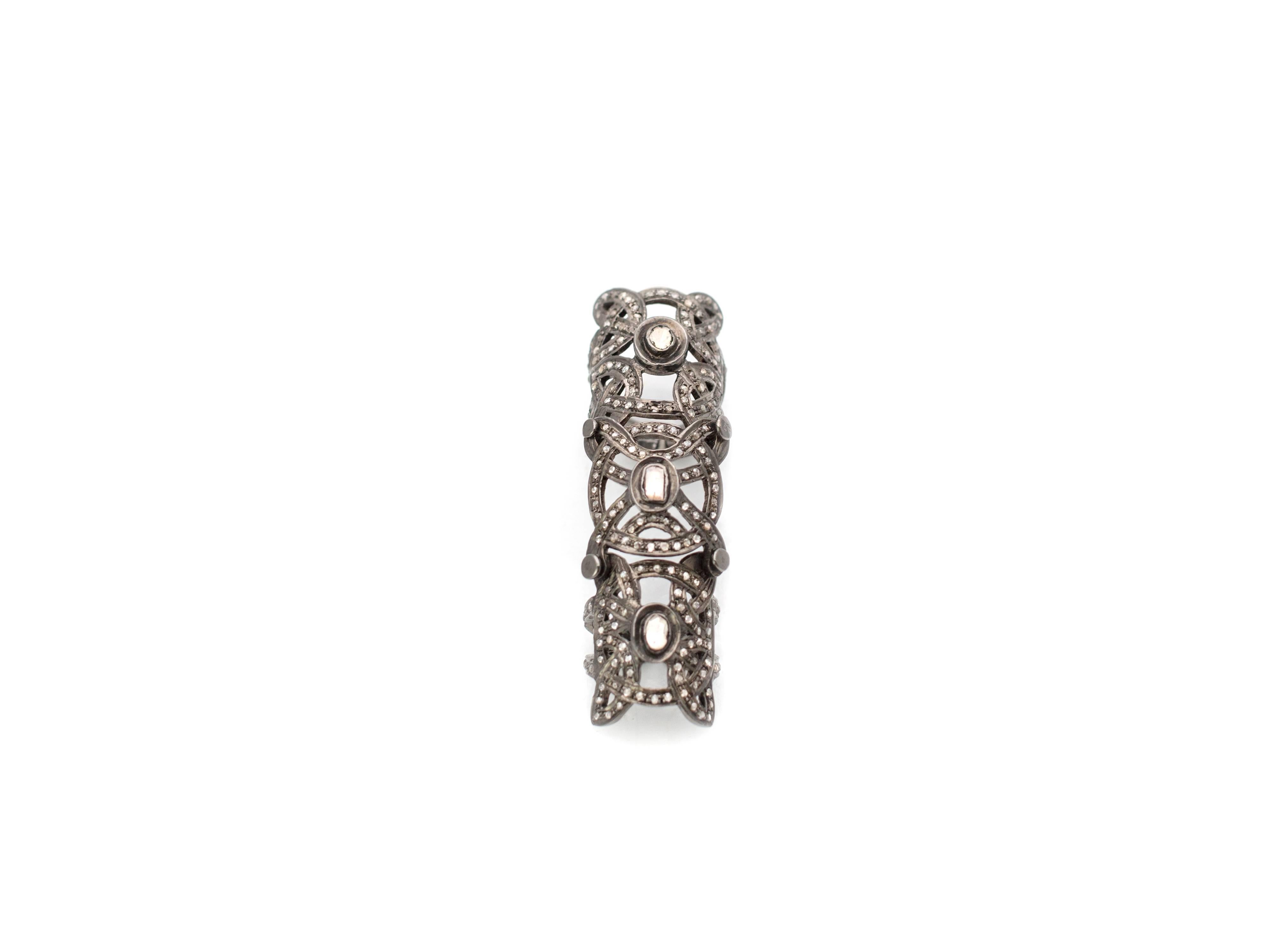 A contemporary interpretation of Medieval armor, this double knuckle ring from Samira13 is encrusted with 3.2 carats of pave and rose cut champagne diamonds set in black rhodium plated sterling silver. It speaks to power and beauty. Ring size 6.5,