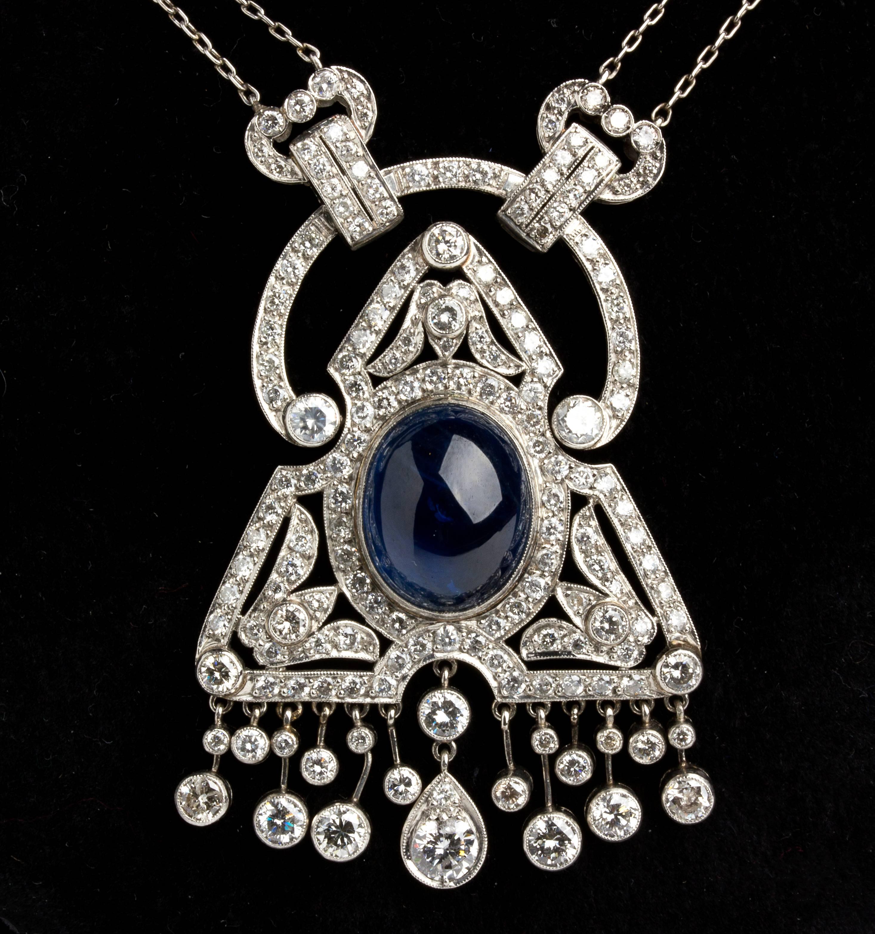 Finely shaped with geometric motif embellished with diamond weighing 5.00 ct, SI clarity, H/I color, centered by cabochon cut sapphire weighing 8.00 ct. Total lenght 400 mm (15 3⁄4 in), pendant dimension 48 x 33 mm (1 57⁄64 x 1 19⁄64 in). Weight