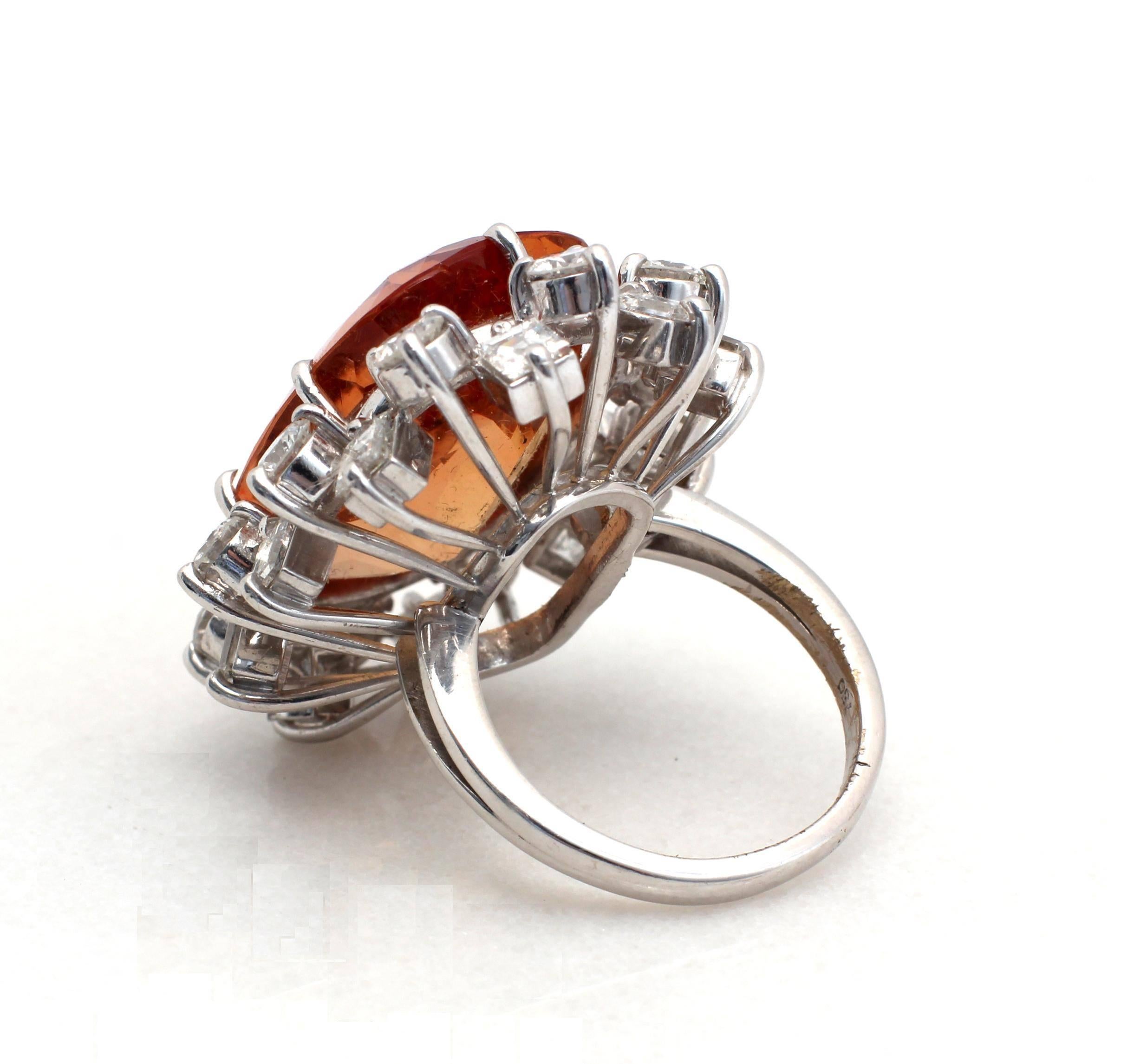 A beautiful natural orange topaz and diamond cocktail ring. The ring features a large topaz 17.20 ct approximately, surrounded by two halos of diamonds totally approximately 3.30 ct ,F-G color, VVS-VS clarity. Weight: 16.3 gr. Ring size: US 5 1/2.