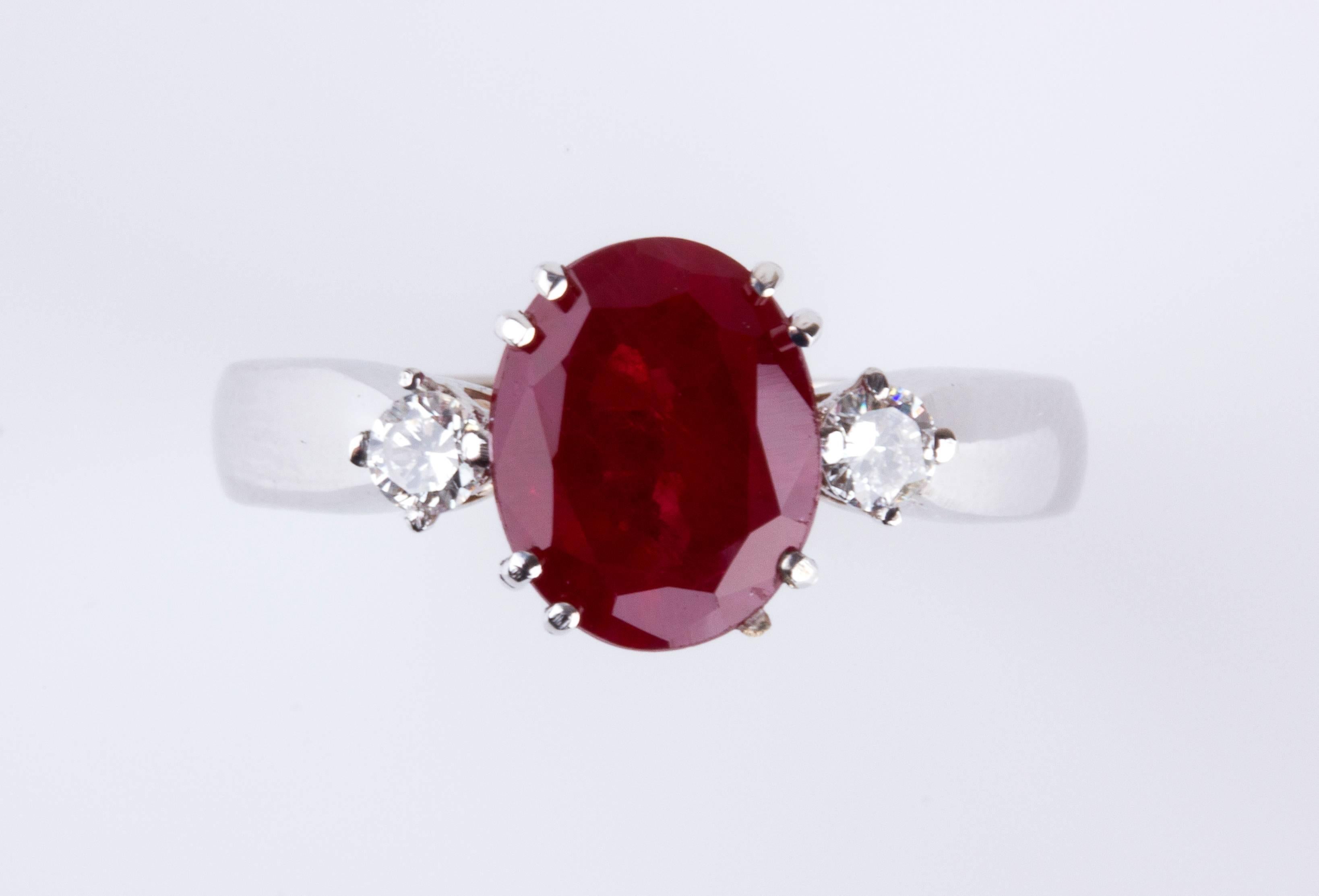 Realized in white gold, set oval shaped ruby weighing 2.30 ct, flanked by two brilliant cut diamond, VS/SI clarity, G/H color, weighing 0.16 ct. Size US 7. Weight 4.90 gr. Italian assay mark 750. Item condition grading: **** good.