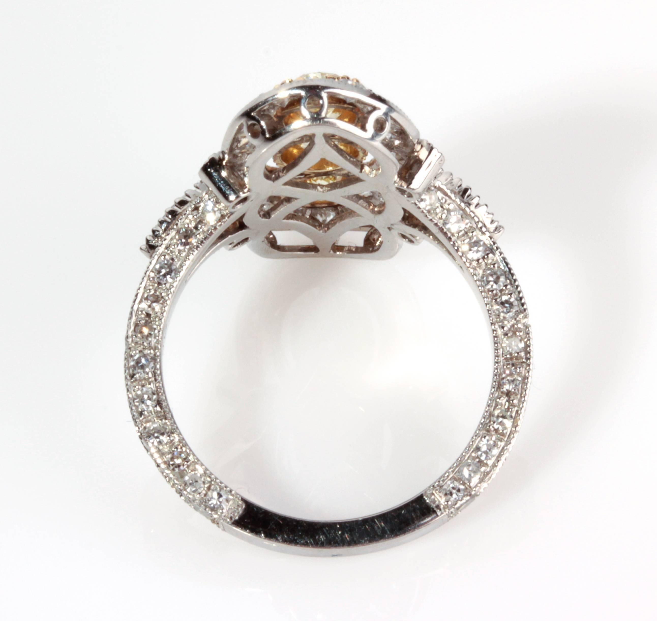 All hand engraved north/south topped ring set with three oval fancy yellow diamonds accented with round brilliant and huit-huit cut diamonds, 3.76 ct. Size US 7.5. Weight 7.7 gr. Stamped PLAT, 18K. 
Item condition grading: **** good