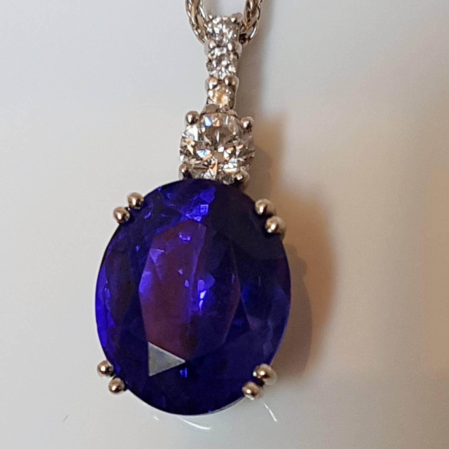 Pendant with deep purple oval tanzanite estimated 8.63ct (13.10mm x 10.73mm x 8.25mm) with 1 diamond 0.30cts, G, SI1, and 3 diamonds 0.08cts total G, VS1, set in platinum.  All stones claw set. Stamped Pt900. With 44cm 18ct white gold chain. This