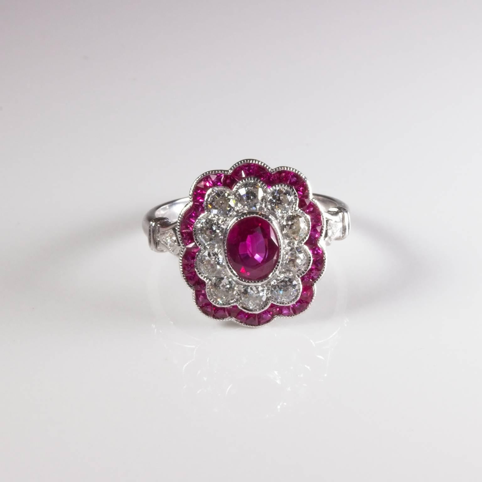 Stunning 18ct white gold ruby and diamond cluster ring bezel set with an oval facetted centre strong pink/red ruby surrounded by 10 old European cut diamonds of 0.07ct each colour I-J clarity VS-SI surrounded by 44 fancy cut rubies and 2 shoulder