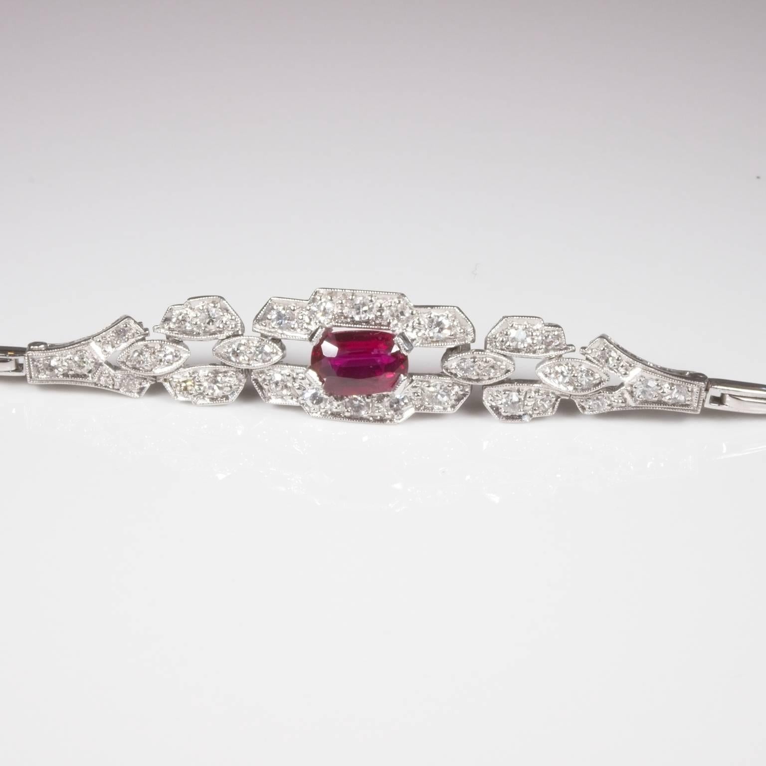 Stunning 18ct white gold ruby and diamond bracelet set with a dark purplish red oval facetted centre ruby surrounded by 34 single cut diamonds I-J/VS-SI on an articulated flexible bar link band with figure of eight safety catch and box clasp.  17cm