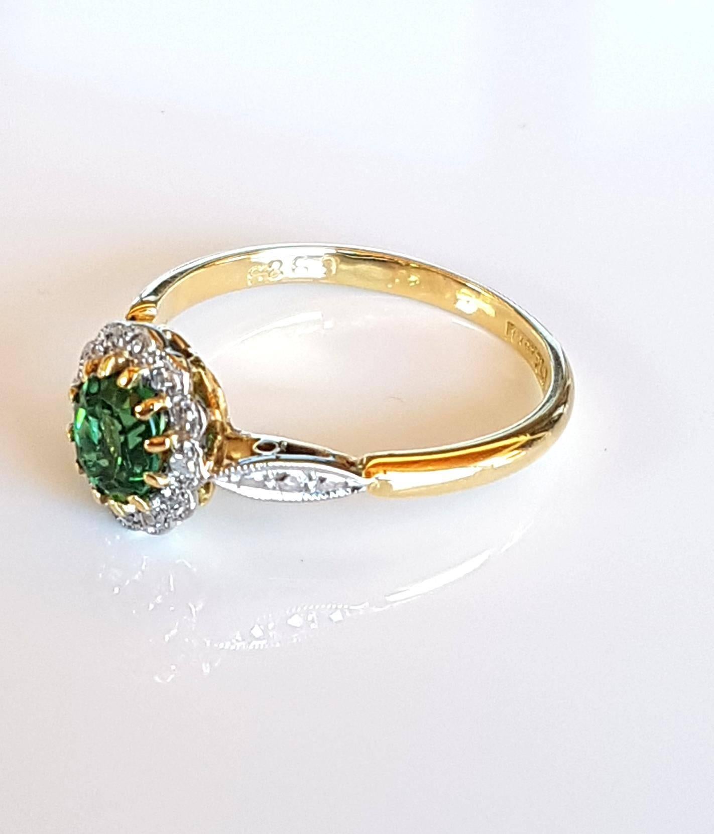 18ct Gold and platinum art deco green tourmaline and diamond ring platinum set with a centre oval facetted cut bluish green tourmaline surrounded by 12 single cut diamonds of total weight 0.06ct colour H, clarity VS and illusion shoulders. Currently