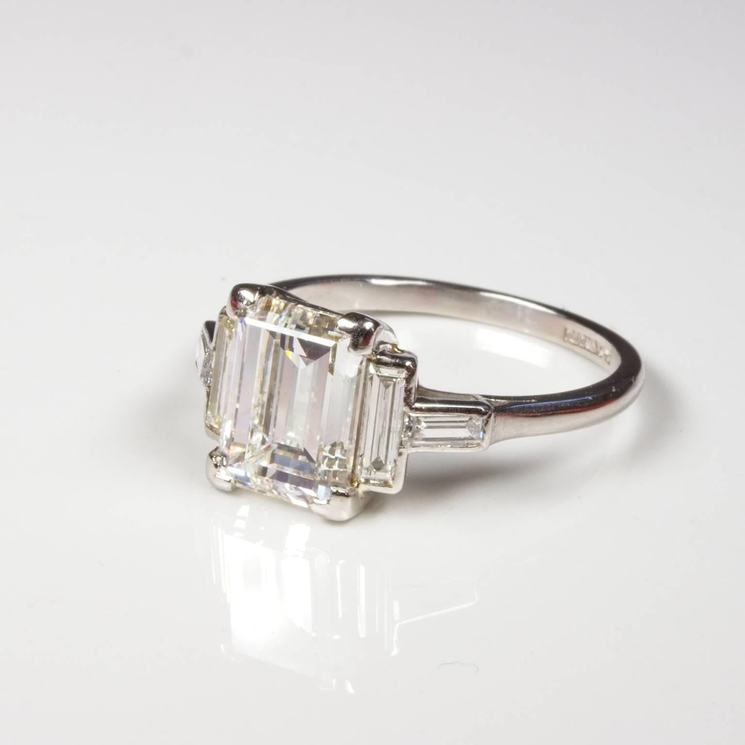 Absolutely stunning art deco platinum diamond engagement ring set with a centre emerald cut diamond of 2.67ct F/VS1 and 4 baguette cut shoulder diamonds of total weight 0.60ct G/VS. What a find!  Currently size S (US=9) and will be safely sized by