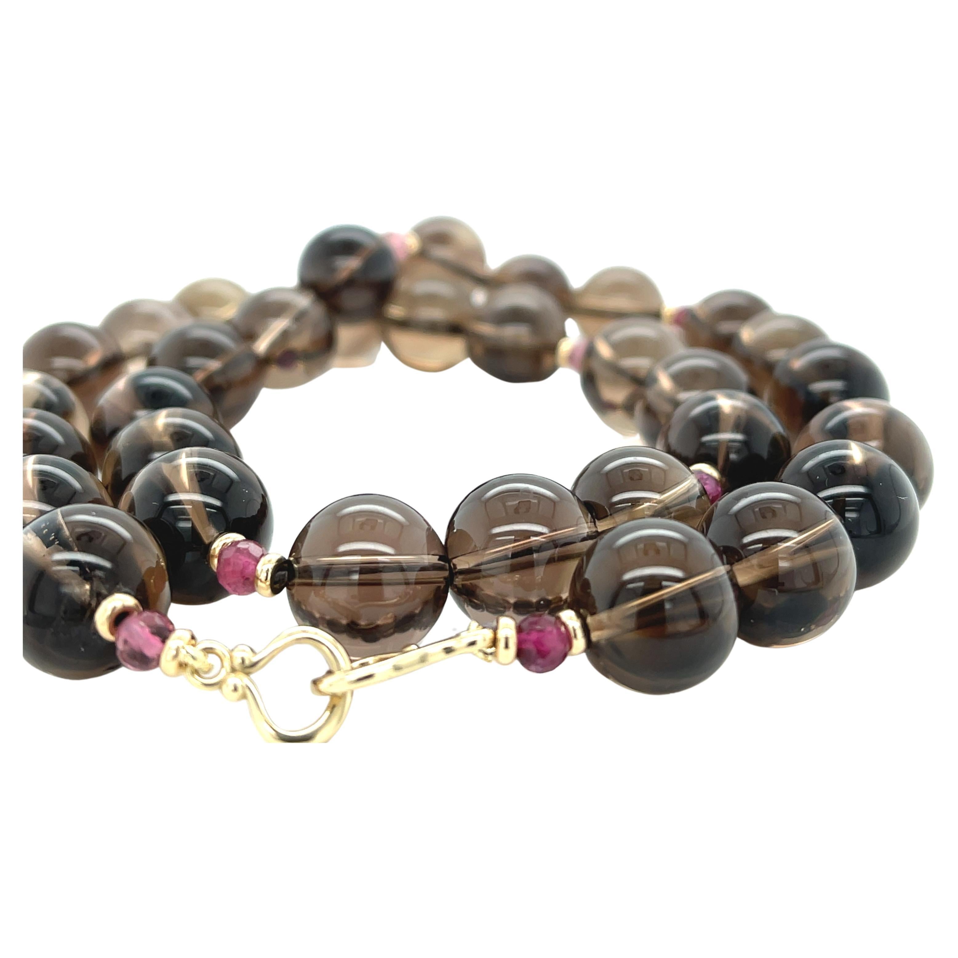 This strand of smoky quartz (commonly referred to as smoky topaz) and pink tourmaline beads is perfect for anyone who loves the warm, rich hues of coffee and chocolate! Beautifully matched 12mm round, transparent smoky topaz beads have been arranged