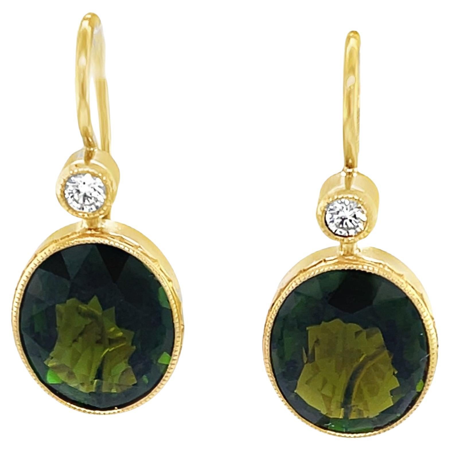 Questi graziosi orecchini pendenti aggiungono un tocco finale a qualsiasi vestito! Grandi ovali di tormalina verde oliva dai colori intensi sono incastonati in oro giallo 18 carati e pendono da diamanti rotondi scintillanti incastonati per un look