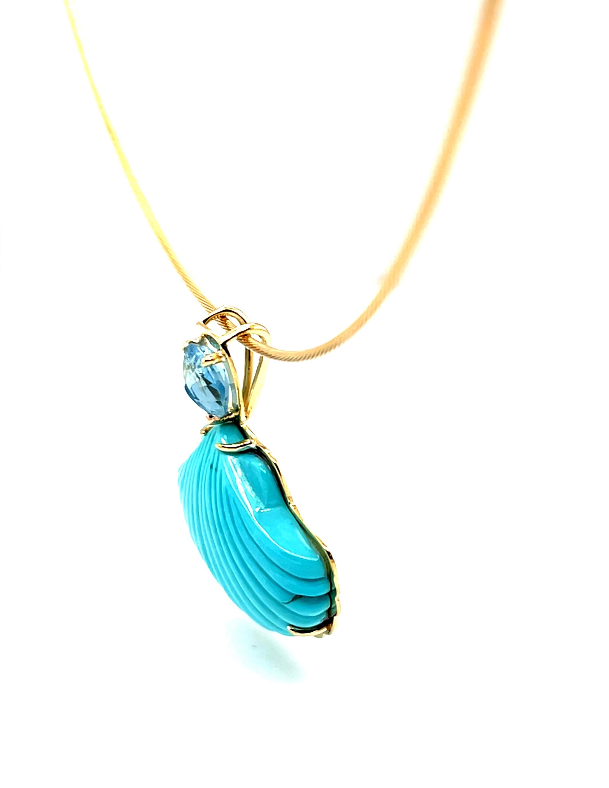 Este llamativo collar colgante presenta una preciosa talla de turquesa de la Mina de la Bella Durmiente de una concha de vieira.  Es una pieza única, tallada a mano en Idar-Oberstein (Alemania) y engastada en oro amarillo de 18 quilates. La turquesa