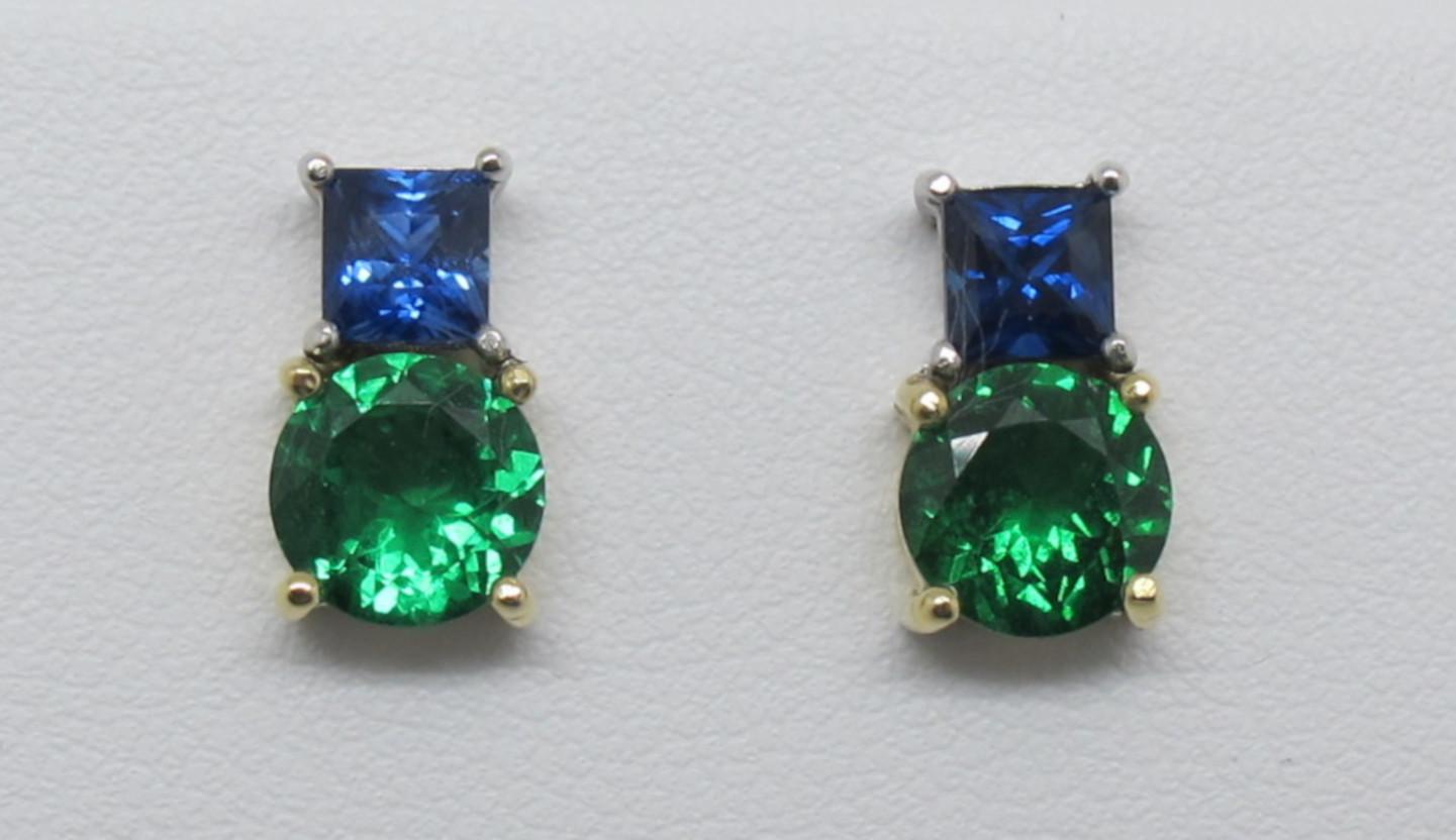This pair of simple color blocked post earrings are truly timeless. We use only stones that are truly gems, having  fine color, cut and clarity.  Two round tsavorite garnets measuring 7mm (2.62 carats) are set with two beautifully bright blue