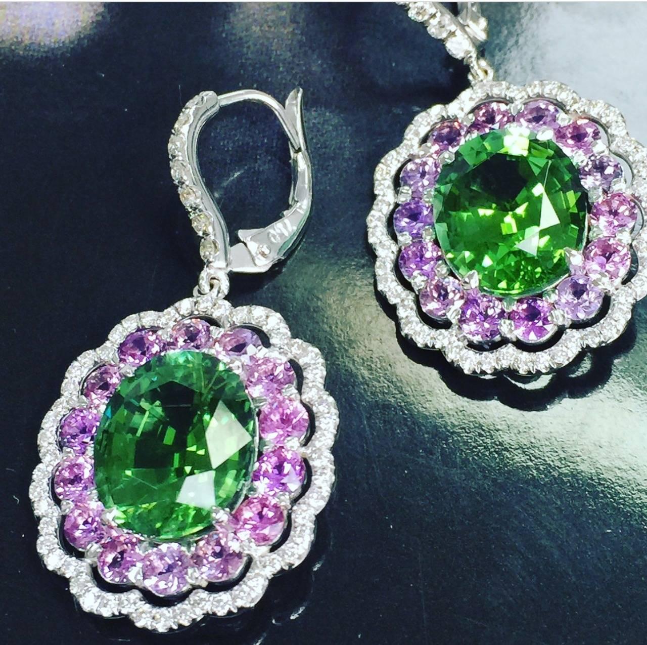 18 K white Gold earrings with Green Tourmaline , surrounded with Purple Sapphires and accented by White Diamonds. The Oval Green Tourmaline in these earrings are Evergreen,( Pantone color for 2017) which is a unique color for the oval tourmalines,