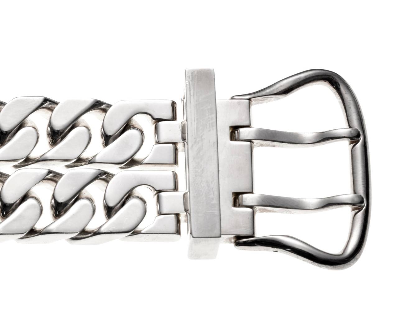 This signed Hermes sterling silver bracelet has a double curb link chain joined by a wide buckle closure. Measures 8