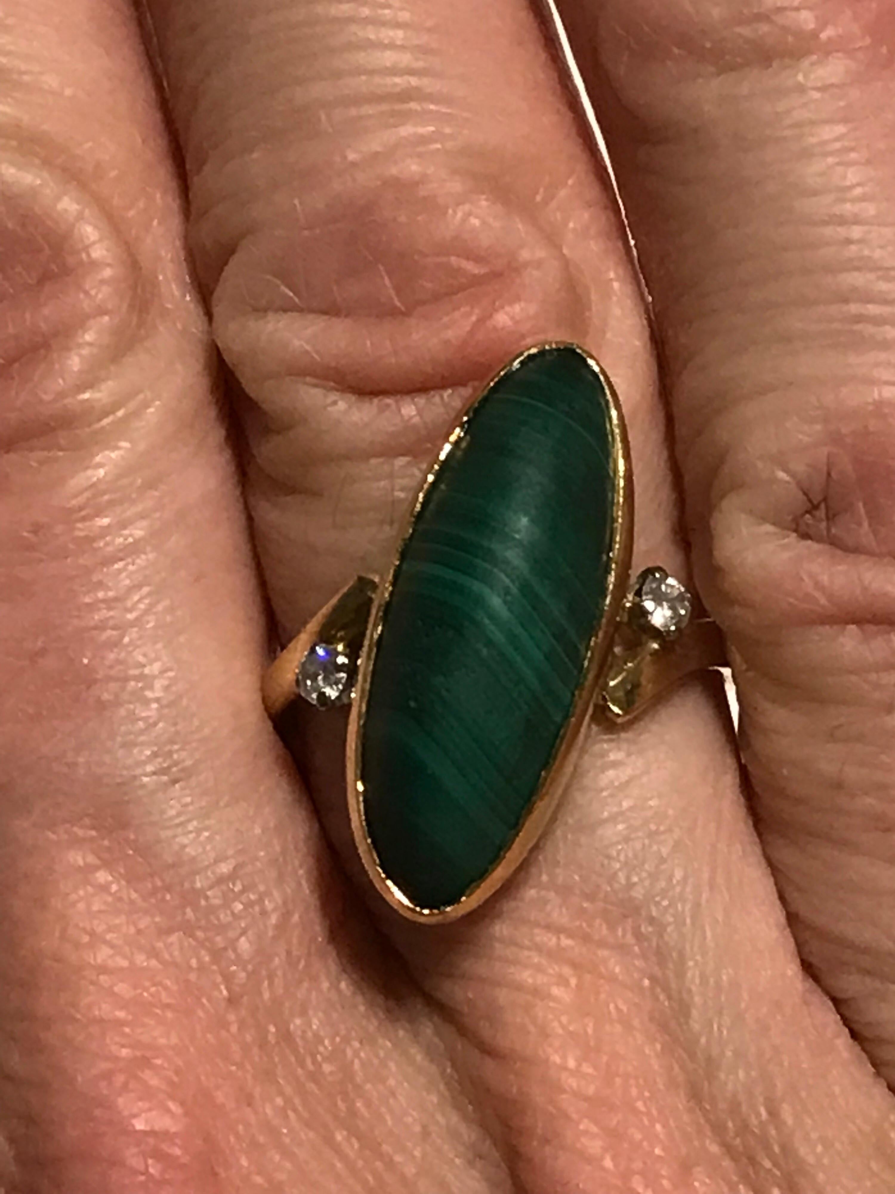 An 18k gold oblique set malachite and diamond 18k dress ring, the estimated diamond weight is 0.10cts and the ring is hallmarked for 18k gold.  The ring is circa 1970. 