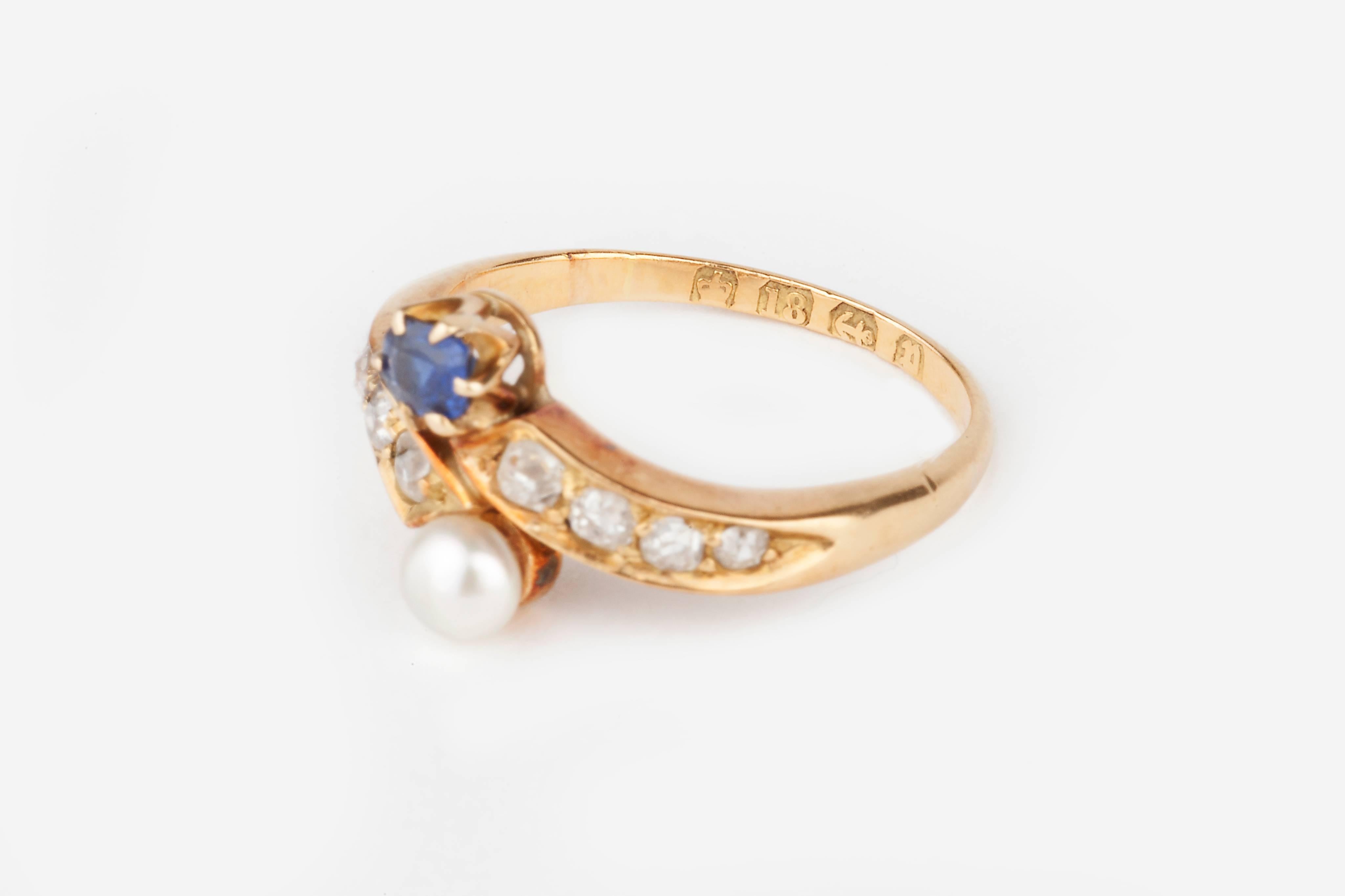 A moi et toi Victorian diamond crossover ring set with a blue natural sapphire and natural pearl with 4 diamond set either side. 