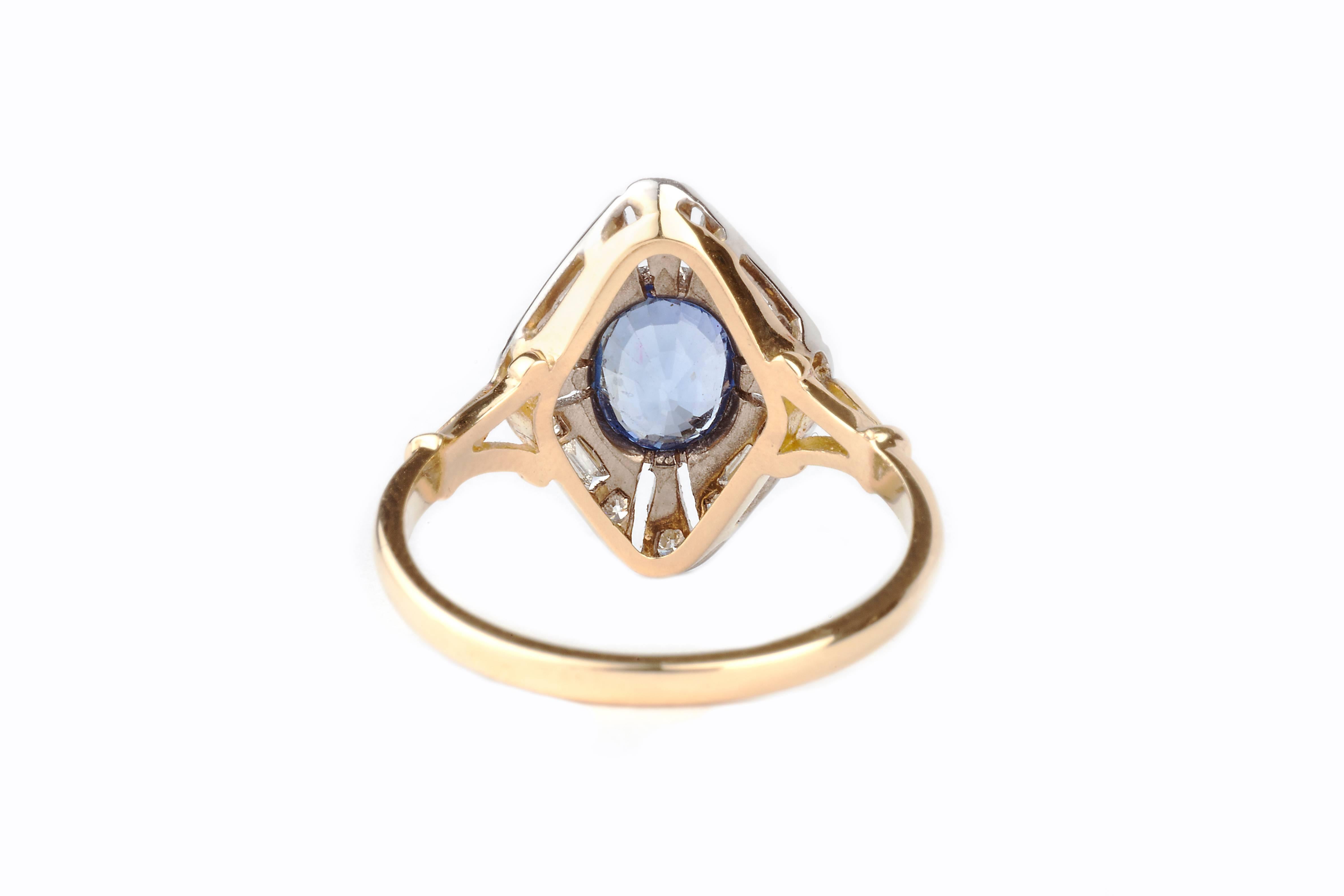 A cornflower blue sapphire ring with baguette and brilliant cut diamonds surrounding it.  The ring is set in 18k gold with a platinum mount and the sapphire is 1.5ct. 