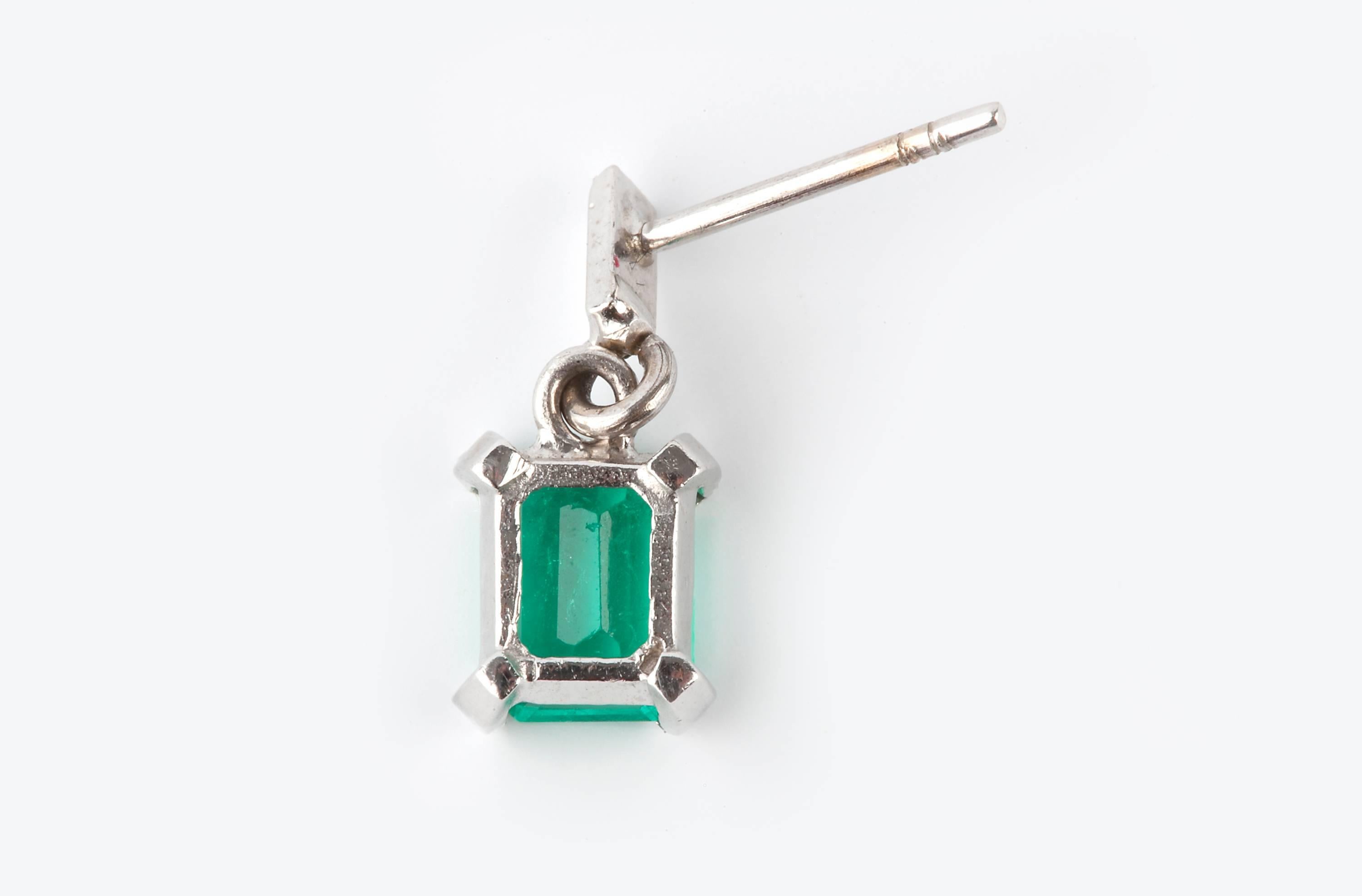 A pair of emerald earrings, AA quality, each set with a emerald cut stone weighing just under one carat, total carat weight about 1.9cts. Set in 18k white gold.