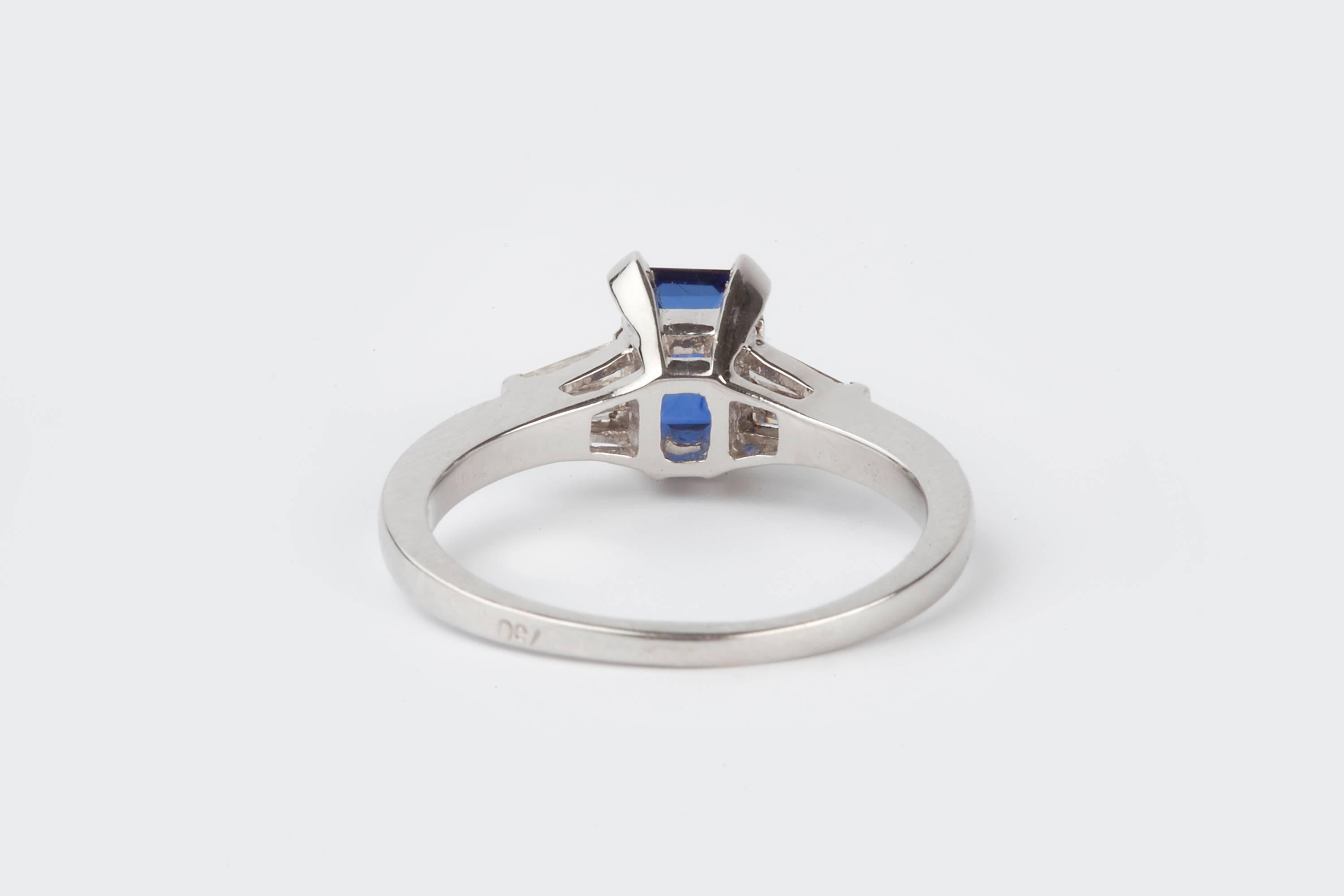 An 18k Gold Royal Blue Sapphire And Diamond five stone ring.  Centrally set with a Sapphire is 0.92cts 7mm x 5mm x 2.36mm, the diamonds are VS/SI and H/L colour, with four  baguette diamonds to the side that measure  1.5mm x 4.5mm long x and width