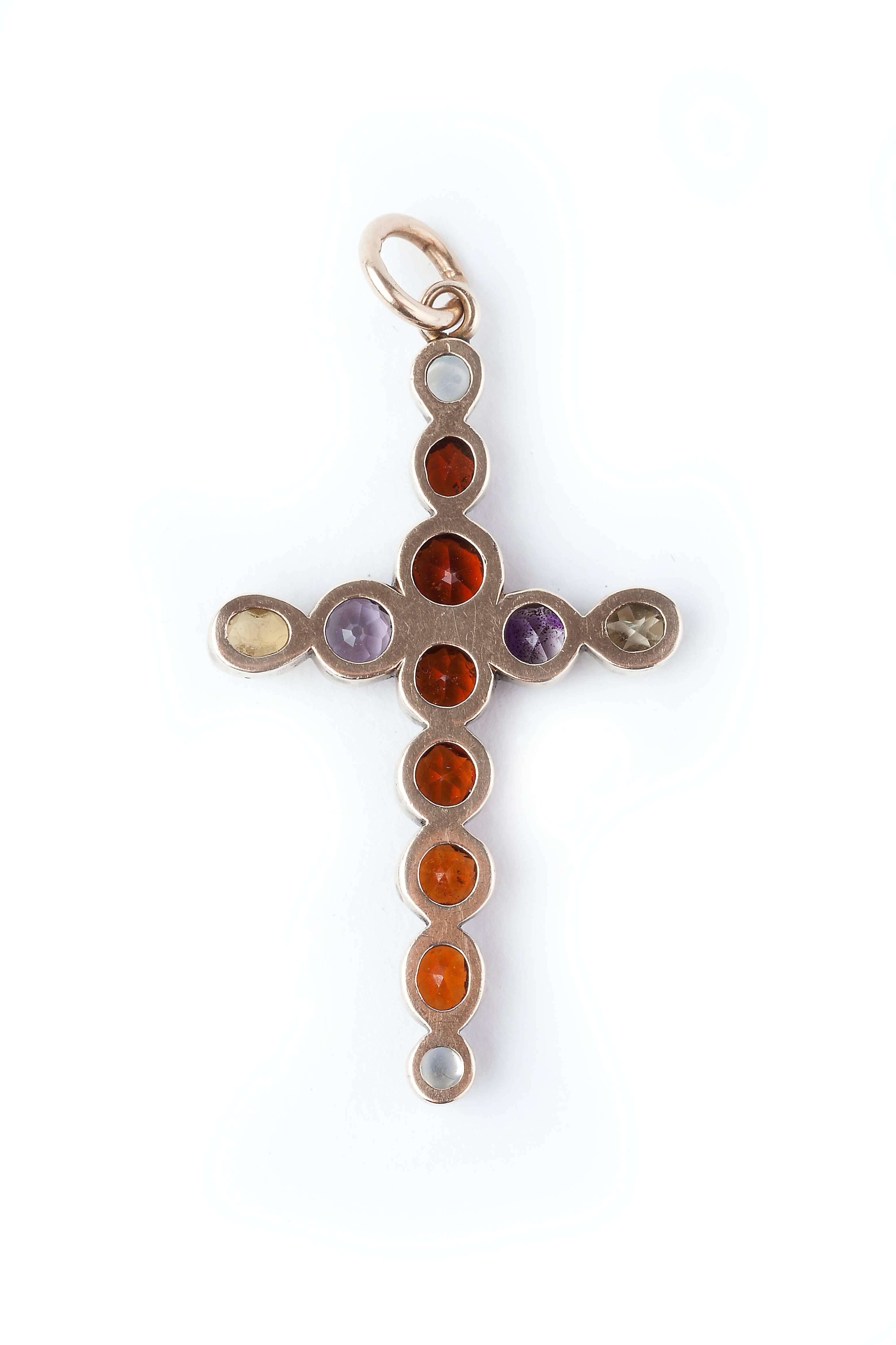 A Gold Early/Mid Victorian Cross, set with hessonite garnets, amethysts,moonstones and zircon and one paste replacement stone. A really beautiful rare antique original item.