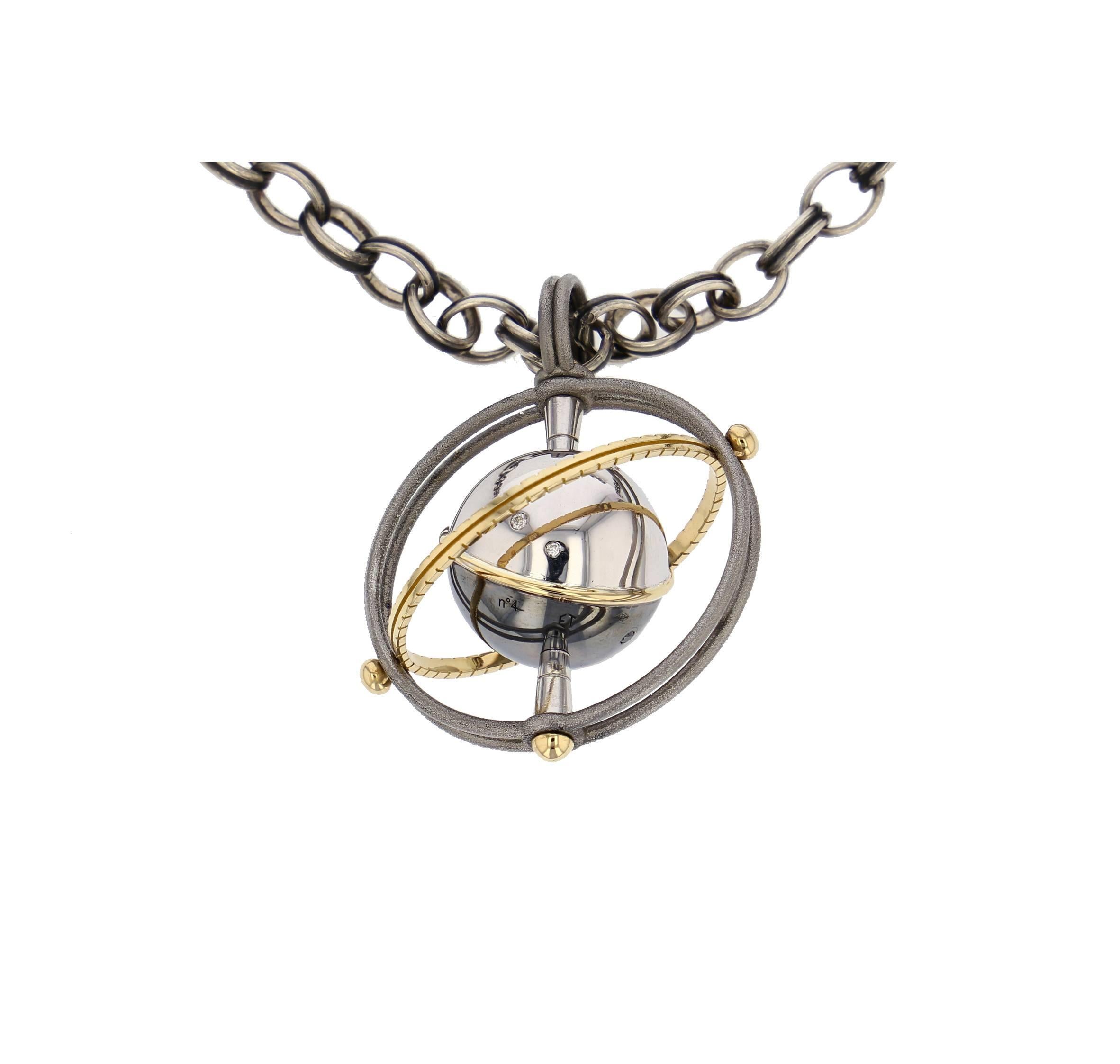 Mir Pendant Gold Silver Diamonds

Pendant on a silver chain. Two polished steel bands holding a rotative system with a white gold axis carrying a white gold and patinated silver globe, circled in yellow gold. This moving planet is set with white and