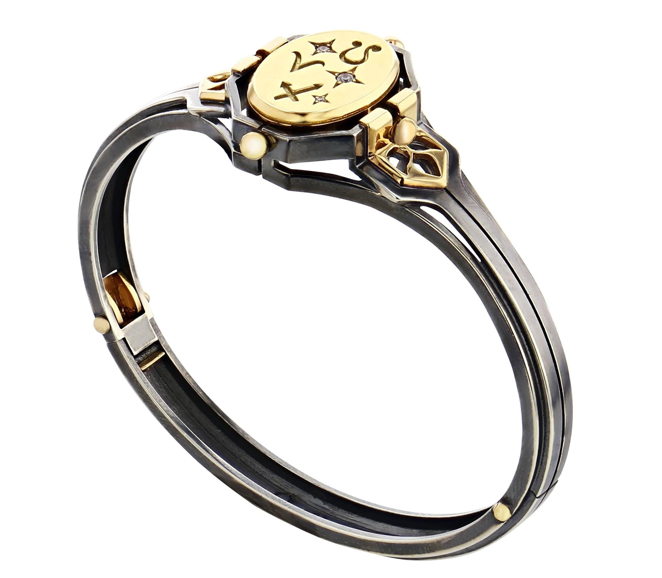 Bangle FEU 
Silver Yellow Gold and Diamond bangle with rotating onyx center piece. 

Patinated silver and gold Bangle. The pivoting central medallion is in gold engraved with zodiac signs and accentuated with set, star-shaped diamonds on one side,