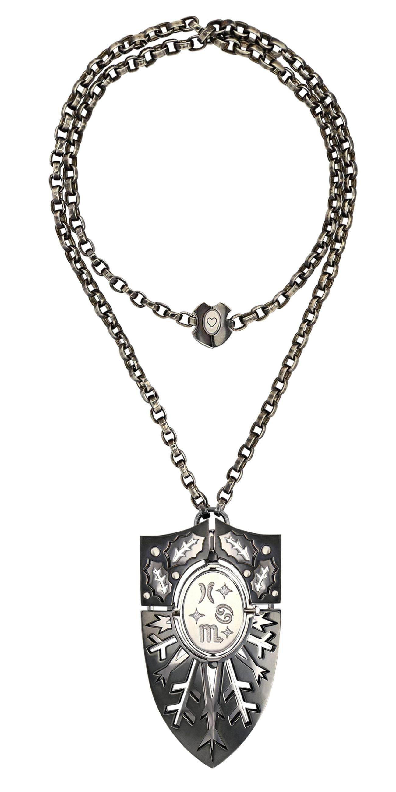 Shield Pendant EAU

Necklace of arms necklace mounted on a patinated silver chain, with a silver and yellow gold clasp engraved with tarot colors. The necklace is pierced, revealing plates with embossed motifs depicting the seasons. The pivoting