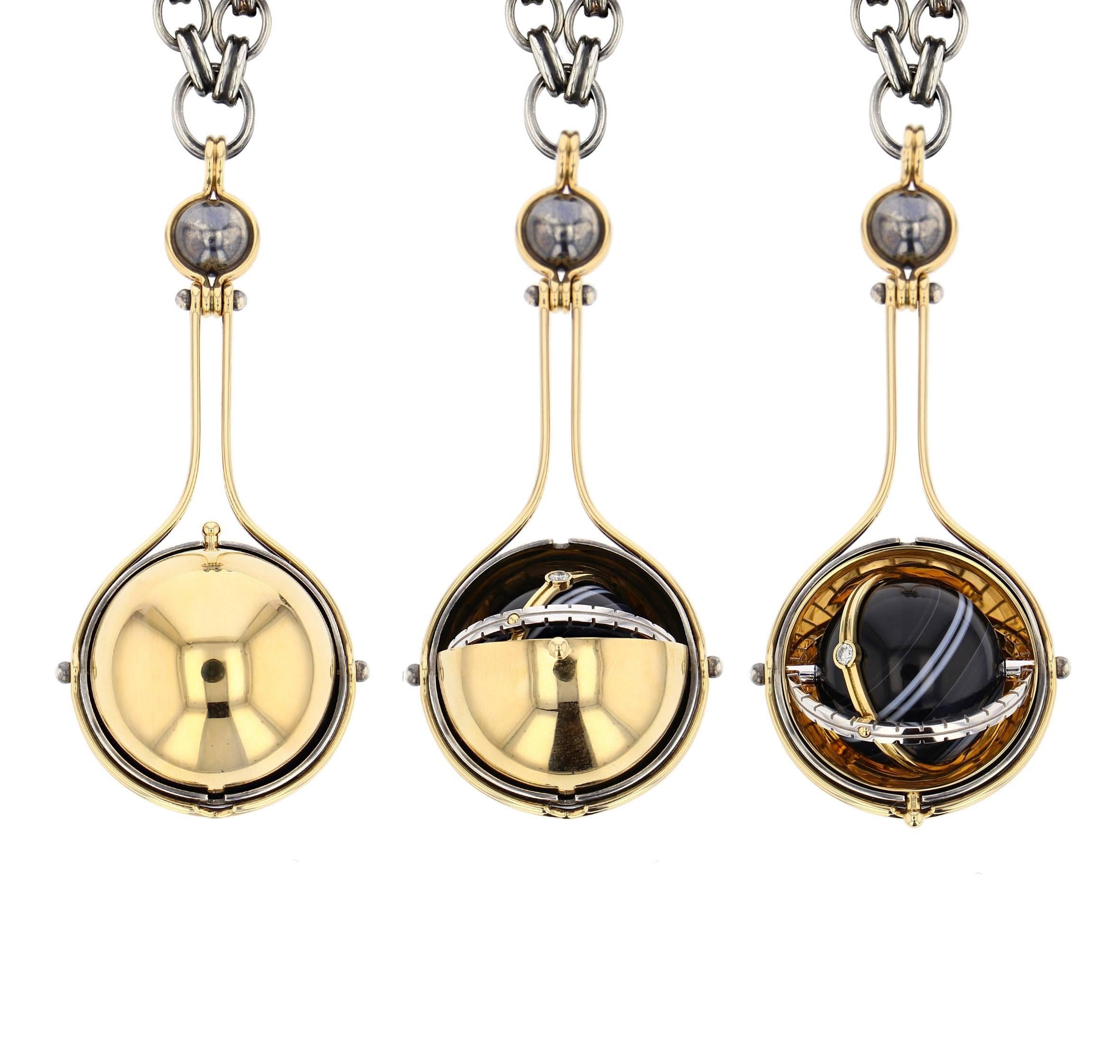 Mecanique Celeste Pluton Pendant Yellow Gold, Onyx and diamond.

Large tarnished and patinated silver pendant. Yellow gold sphere rotating on a distressed silver structure and opening on an onyx globe itself, surrounded by a white gold satellite