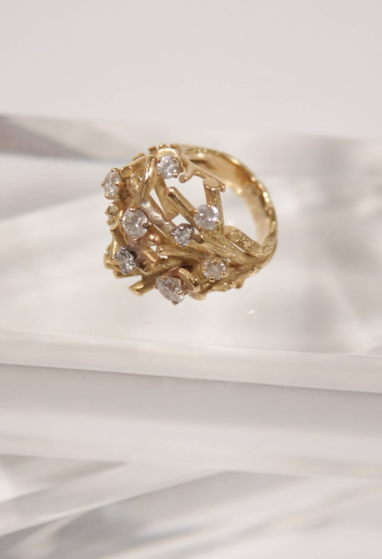 This beautiful ring is composed of a textured 18k gold adorned with diamonds. 
An absolutely effortlessly gorgeous 1970's piece.
The rind is quite substantial with a nice weight.
The Diamonds are all set as if being grasped by tree branches of 18K
