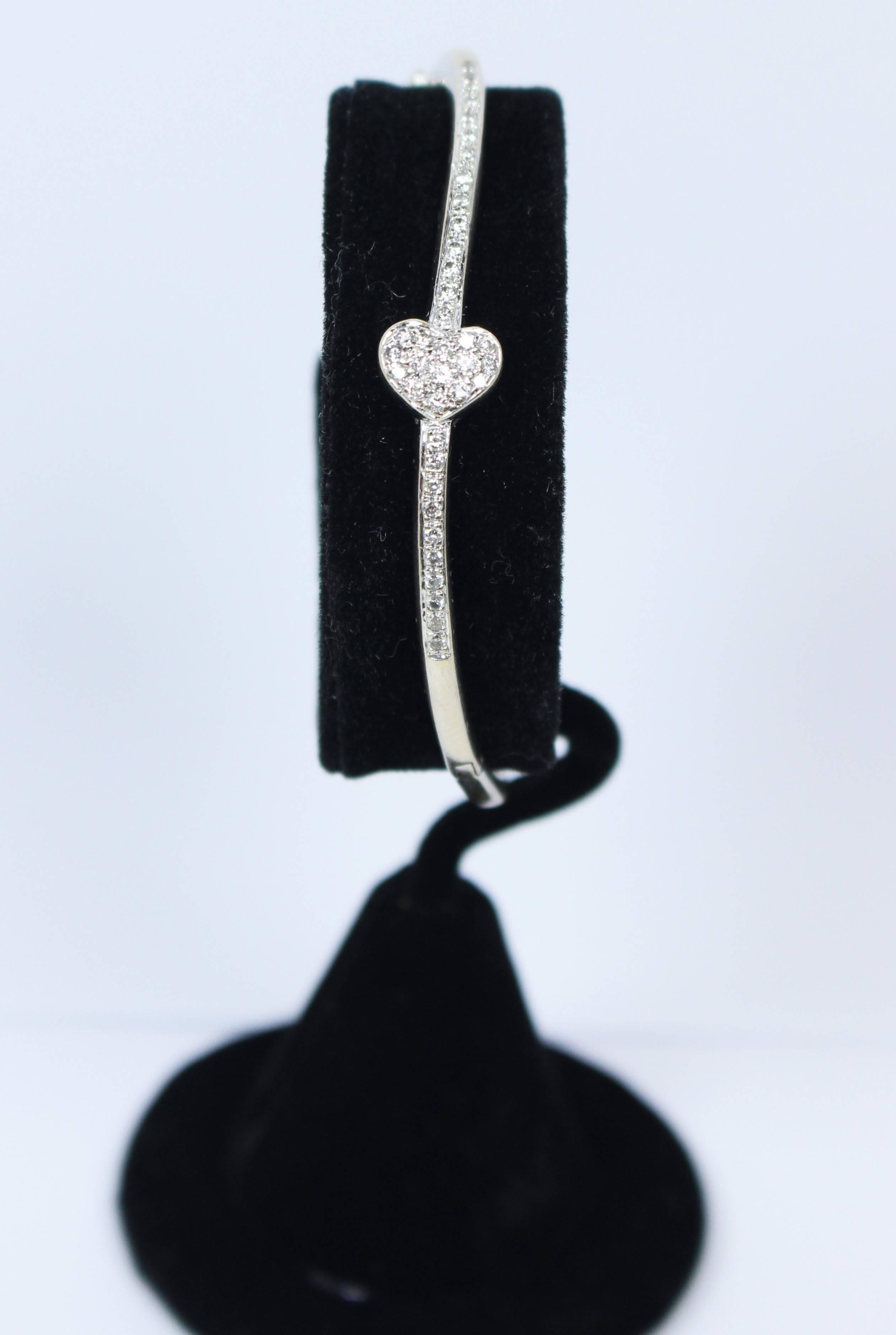 This bangle is composed of 18KT white gold with pave diamond details and a heart design. There is a hinge opening. In excellent vintage condition.

Specs: 
18KT White Gold
Approximately 0.50 Carats Diamonds
 
Length: 6 7/16