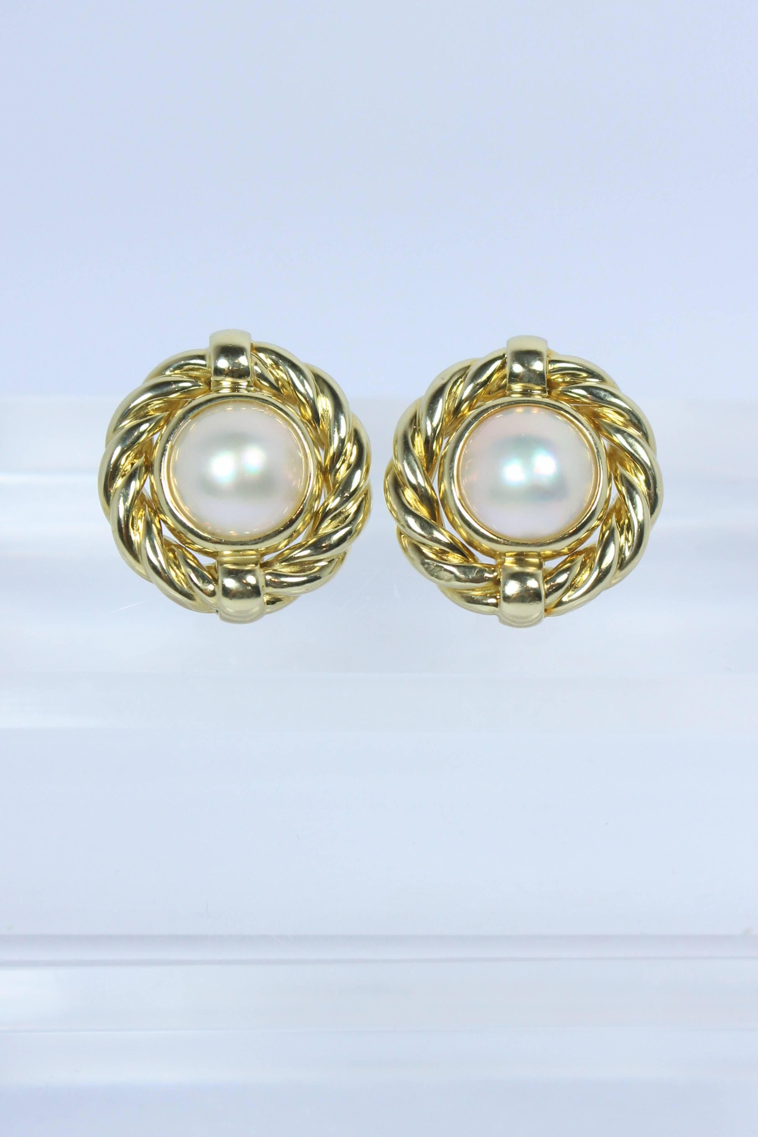 These earrings are composed of 18KT yellow gold with Mabe Pearl. There is a post backing with clip. In excellent vintage condition.

Specs: 
18KT Yellow Gold
Mabe Pearl
  
Length: 7/8