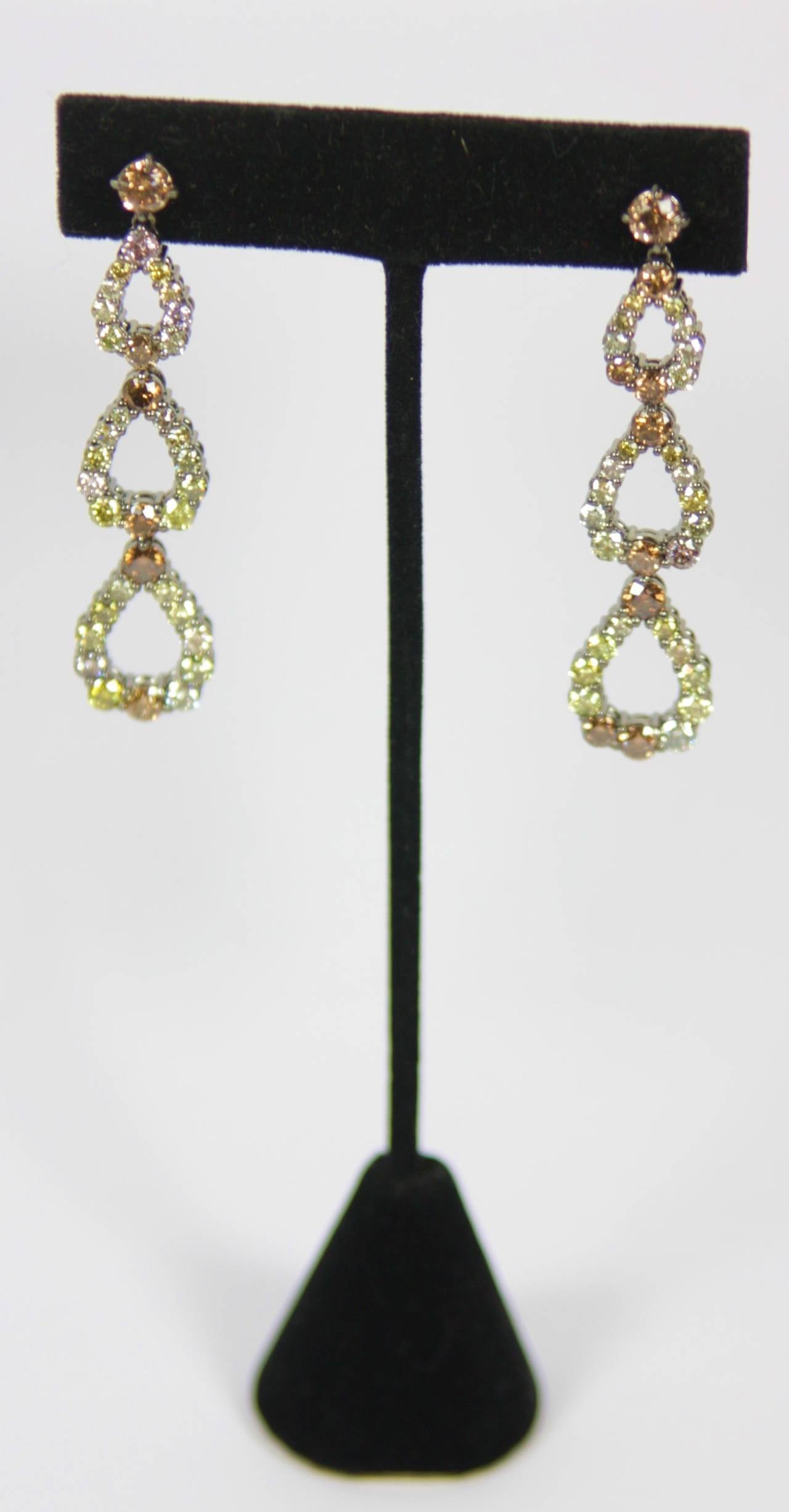 The earrings are composed of  approximately 7.50 carats of fancy diamond round cuts in various colors. The 18kt gold has an added contrast of black rhodium. An absolutely wonderful pair of drop style earrings.

Specs:
18 KT Gold with black