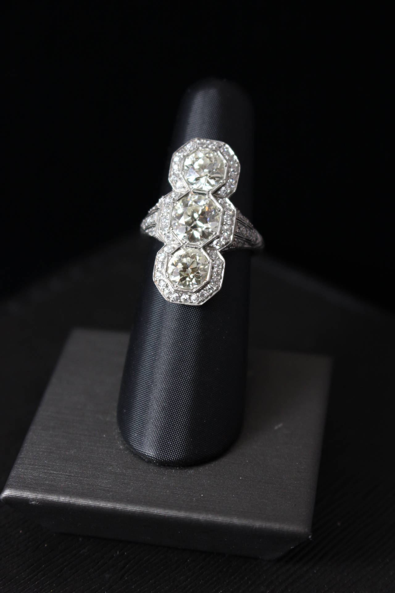 This is a lovely Edwardian diamond cocktail ring. The ring features three KVS European cut diamonds with a center stone weighting approximately 2.10 carats and the two additional diamonds weighting approximately 1.20 carats each. Size 6.5 (easily