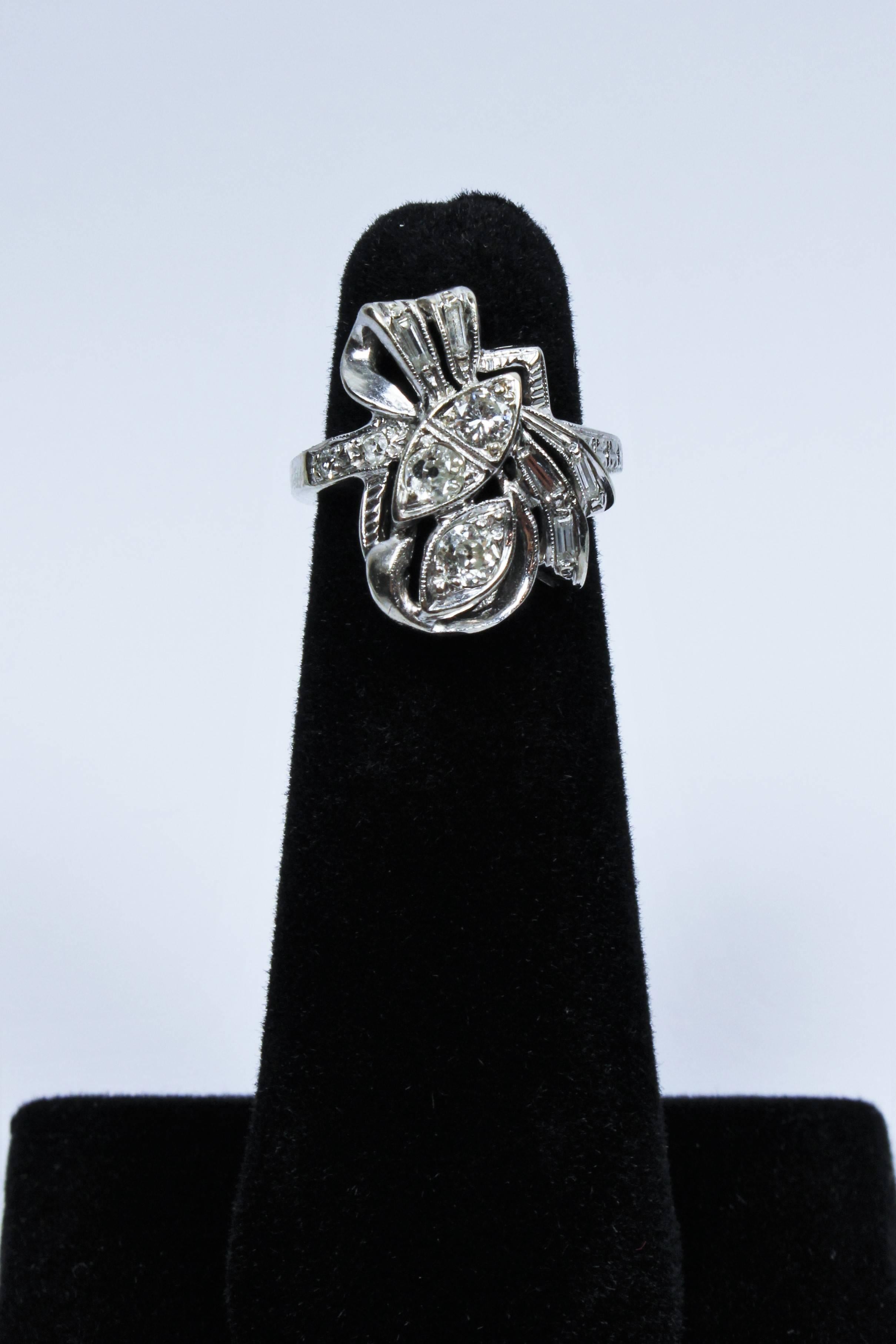 This 1930s vintage White Gold ring is composed of 14KT white gold with diamonds. 

Specifications : 
14 KT White Gold 
Old Round Mine Cut Diamonds:  ONE .15   One .10  TWO .10
Baguettes:  FOUR .04  ONE .03

Size 5.5