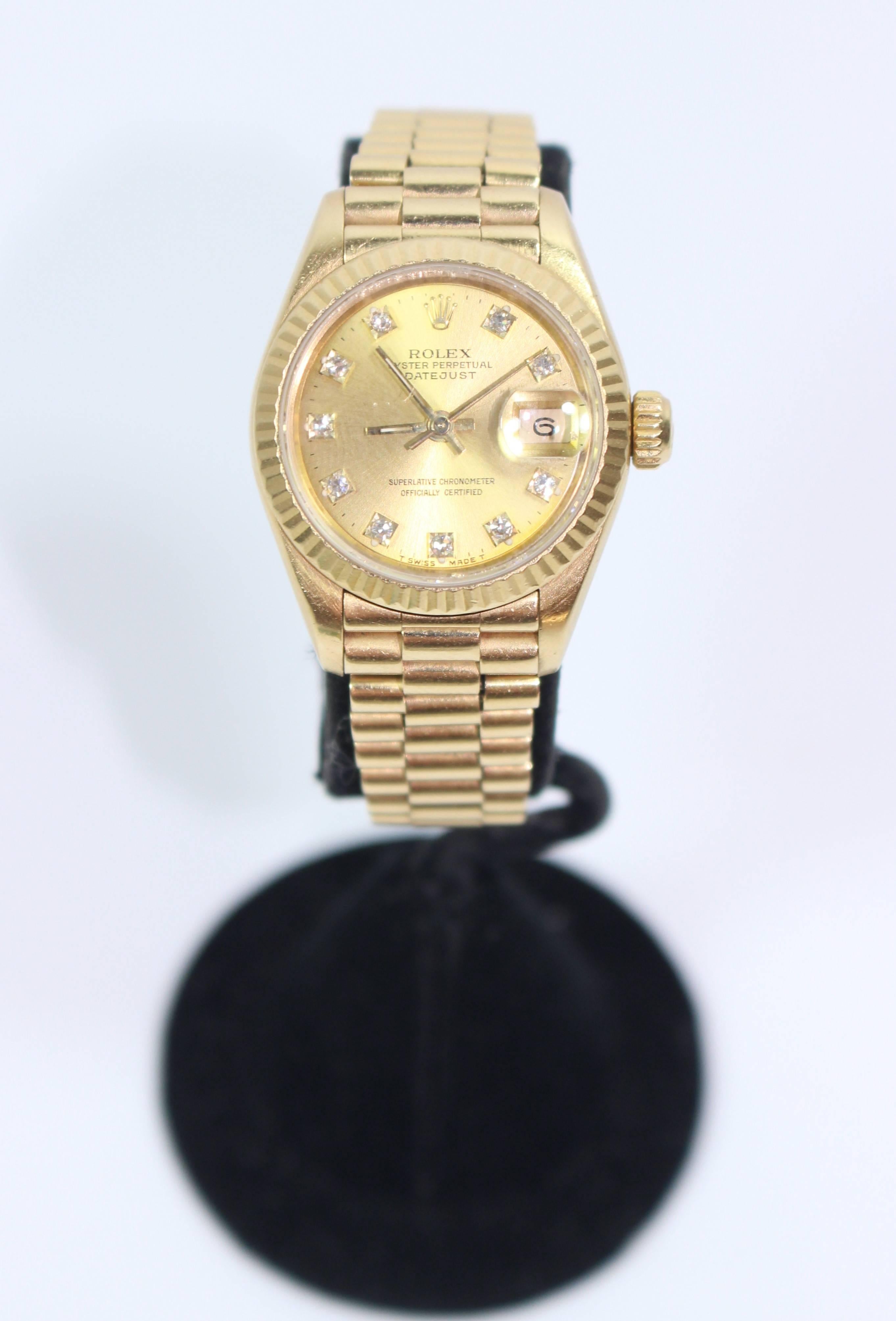 This fabulous Rolex  watch presented by The Paper Bag Princess of Beverly Hills features; Automatic winding, 29 jewels, Quickset date, sapphire crystal. 18k yellow gold case with fluted bezel (26mm diameter). Champagne dial with factory diamond hour