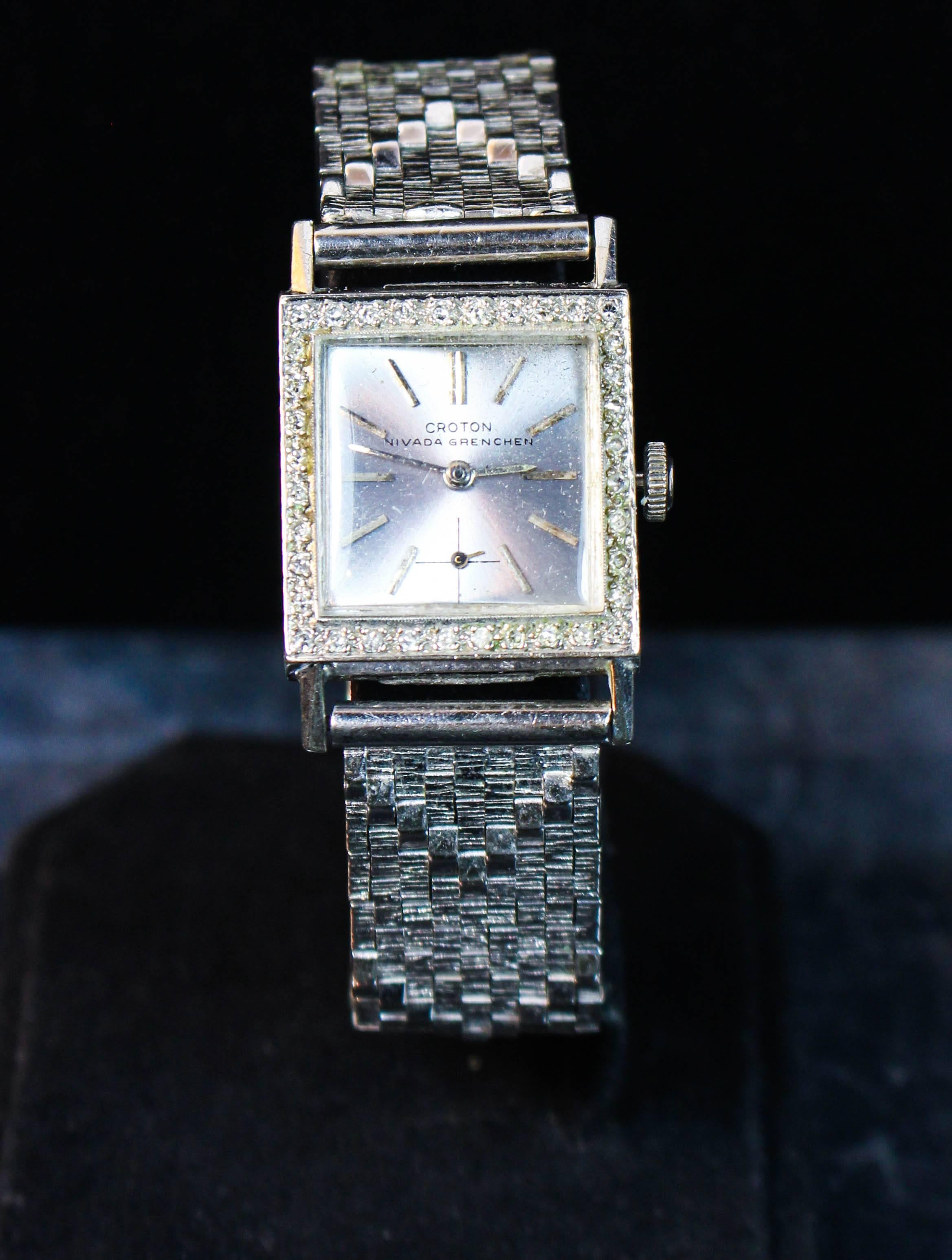 This Croton Nivada Grenchen watch is composed of 14kt white gold. Features woven patterned straps with a diamond pave face. There is an adjustable closure. In excellent condition.

Please feel free to ask any questions you may have, we are happy to