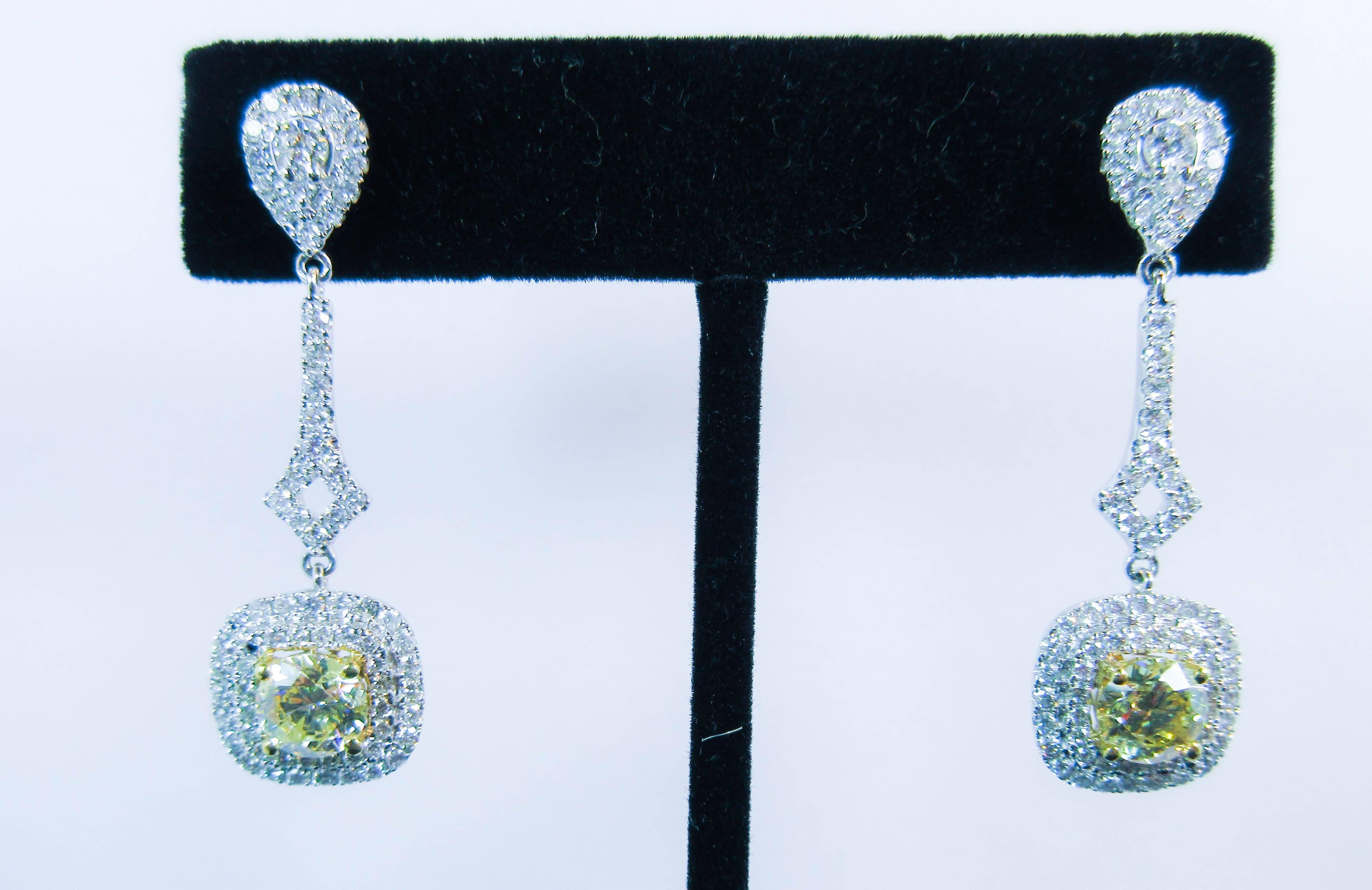 These earrings are composed of an 18KT white gold with stunning yellow round cut center diamonds, accented with pave white diamonds. Striking drop style. In excellent condition.

Please feel free to ask any questions you may have, we are happy to