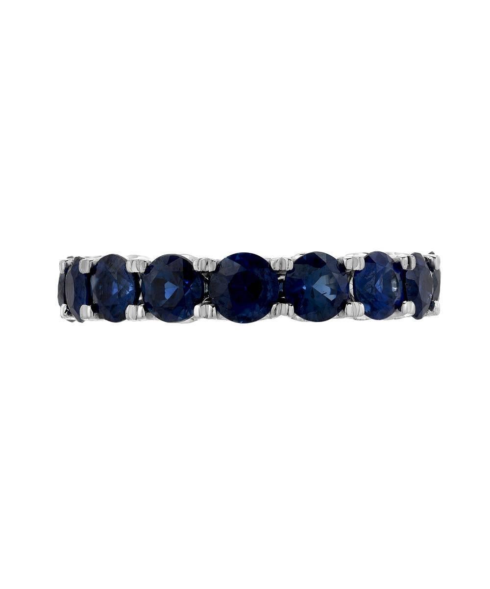 This simple eternity band crafted in 18 karat white gold features 3.52 carats of matching 3.8 mm round intense matching royal blue sapphires. The pictured ring is a standard US size 5 and features a scalloped prong setting. 

Sapphires are heat
