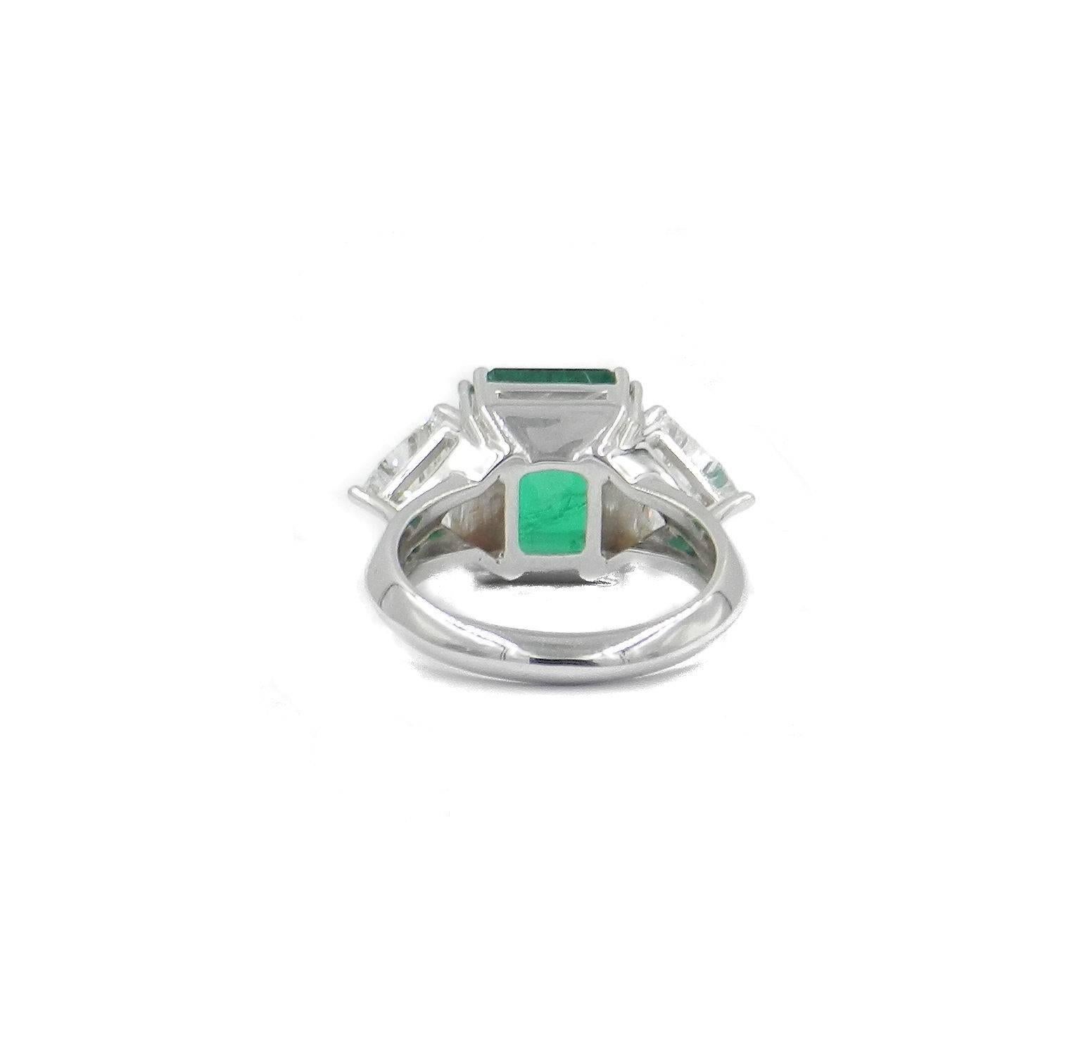 Natural green colombian emerald octagonal shape weight carat 5.48 with Gubelin certificate. Two triangular white diamonds total carat weight 1.65
These three beautiful stones have been set in a classic shape ring in 18kt white gold. Surely a