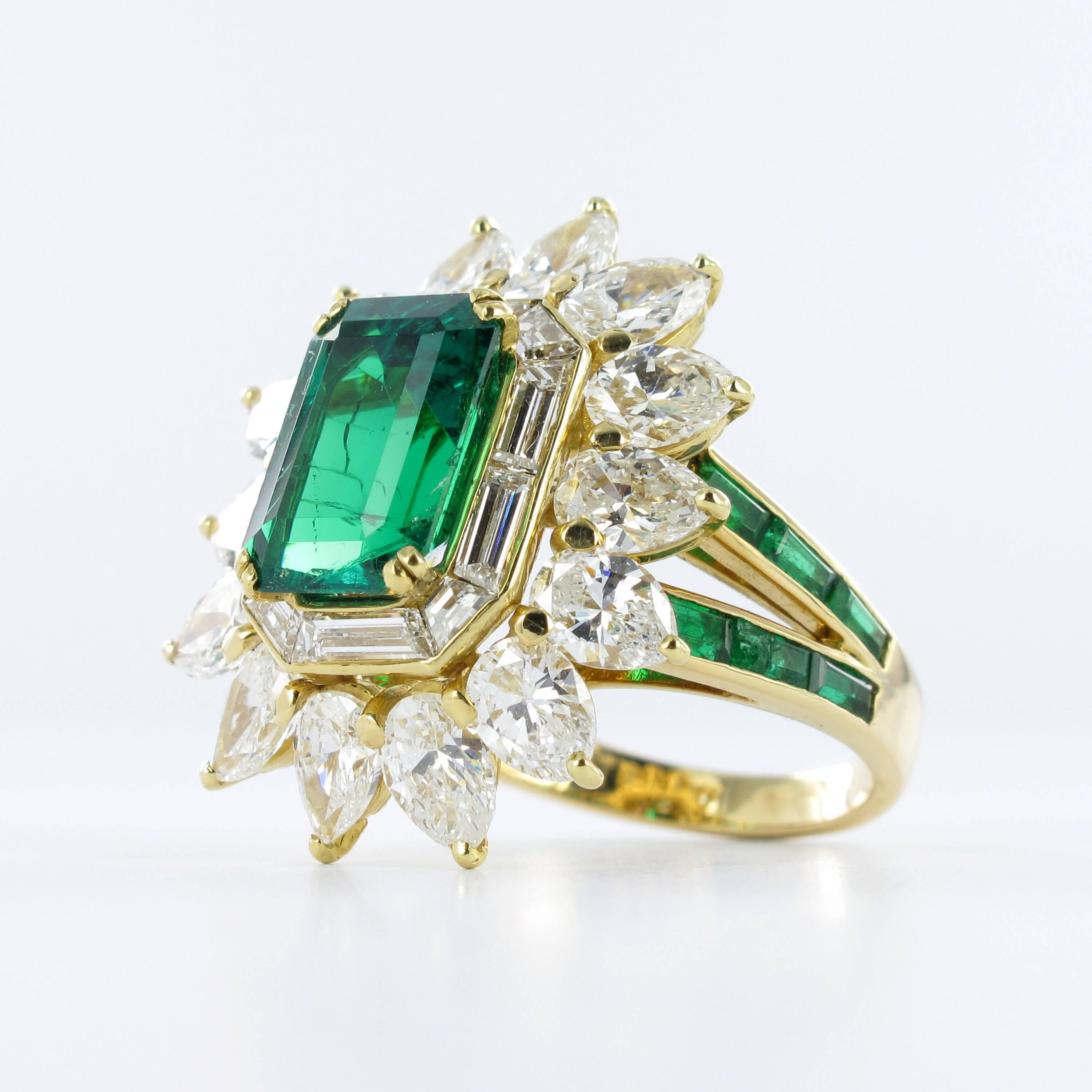 Colombian emerald and diamond ring by Mauboussin. Set with an octagonal step-cut emerald with an approximate weight of 3.30 carats, encircled by a single row of ten baguette cut diamonds in a bezel setting and further set with fourteen pear shape