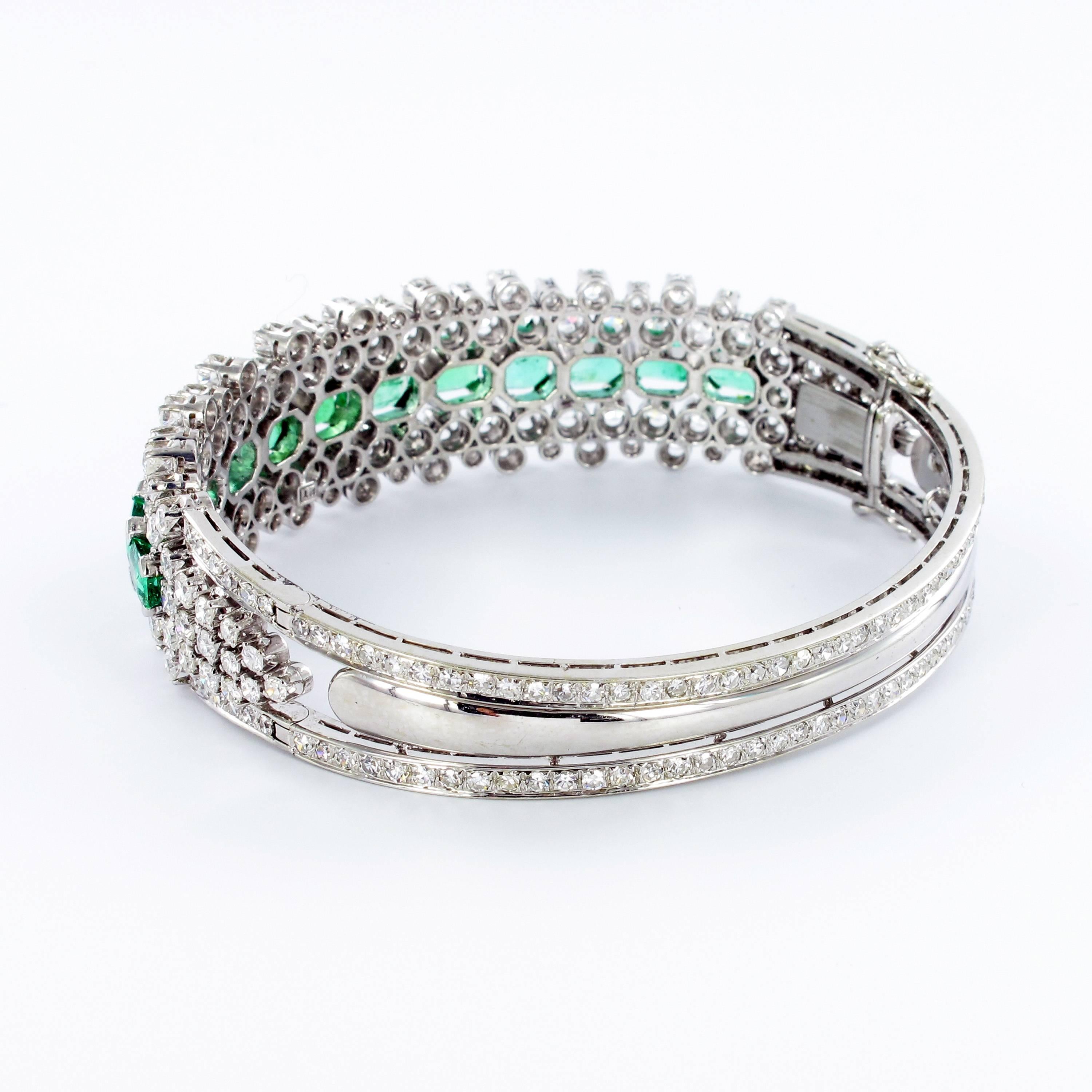 One 18k white gold bangle featuring 12 octagonal cut emeralds, total weighing approximately 7.70 carats. Further prong set with 223 brilliant and single cut round diamonds, total weighing approximately 6.50 carats, G/H-vs/si quality. Figure eight
