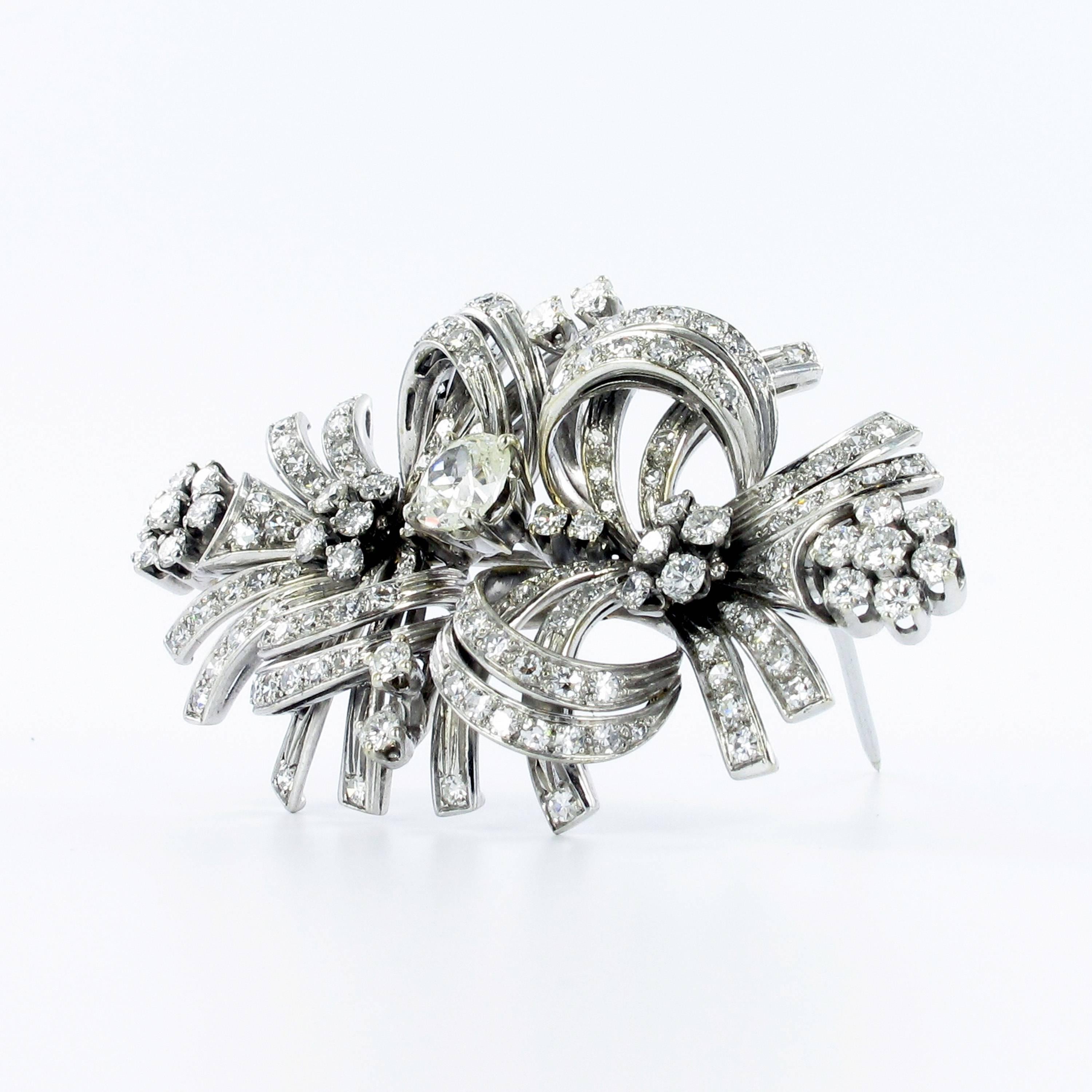 This classic brooch is crafted in 18k white gold. Prong and pave-set with 154 brilliant and single cut diamonds with G/H colour and vs clarity. Total weight approximately 2.50 carats. Centered around an old cut cushion shape diamond of approximately