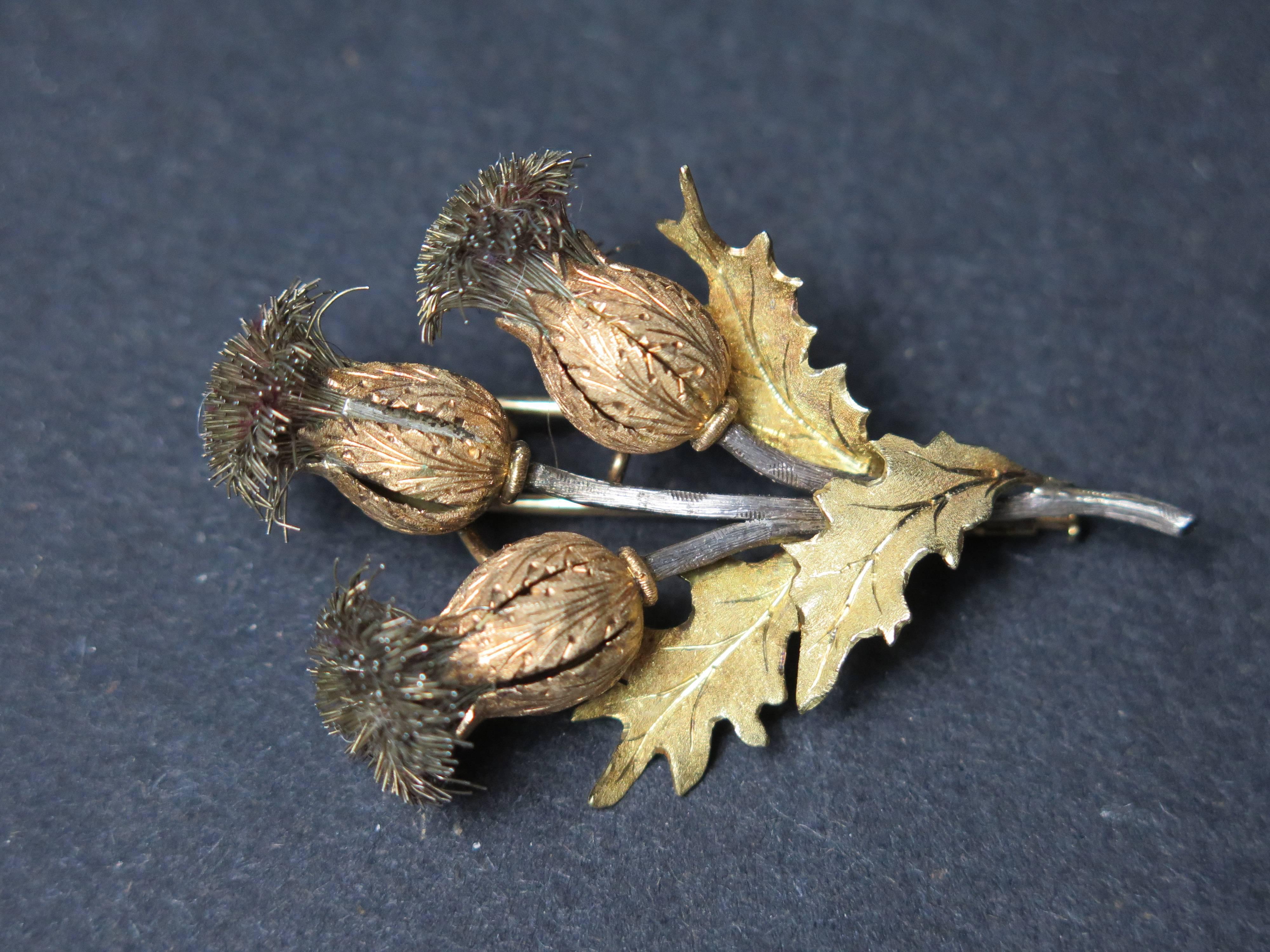 An exquisite triple thistle brooch by Mario Buccellati. The thistle heads crafted of textured rose gold, with silver wire thistles on textured silver stems, with 18k yellow gold leaves. Signed M. Buccellati and 750 for 18K gold.

2.25" high,