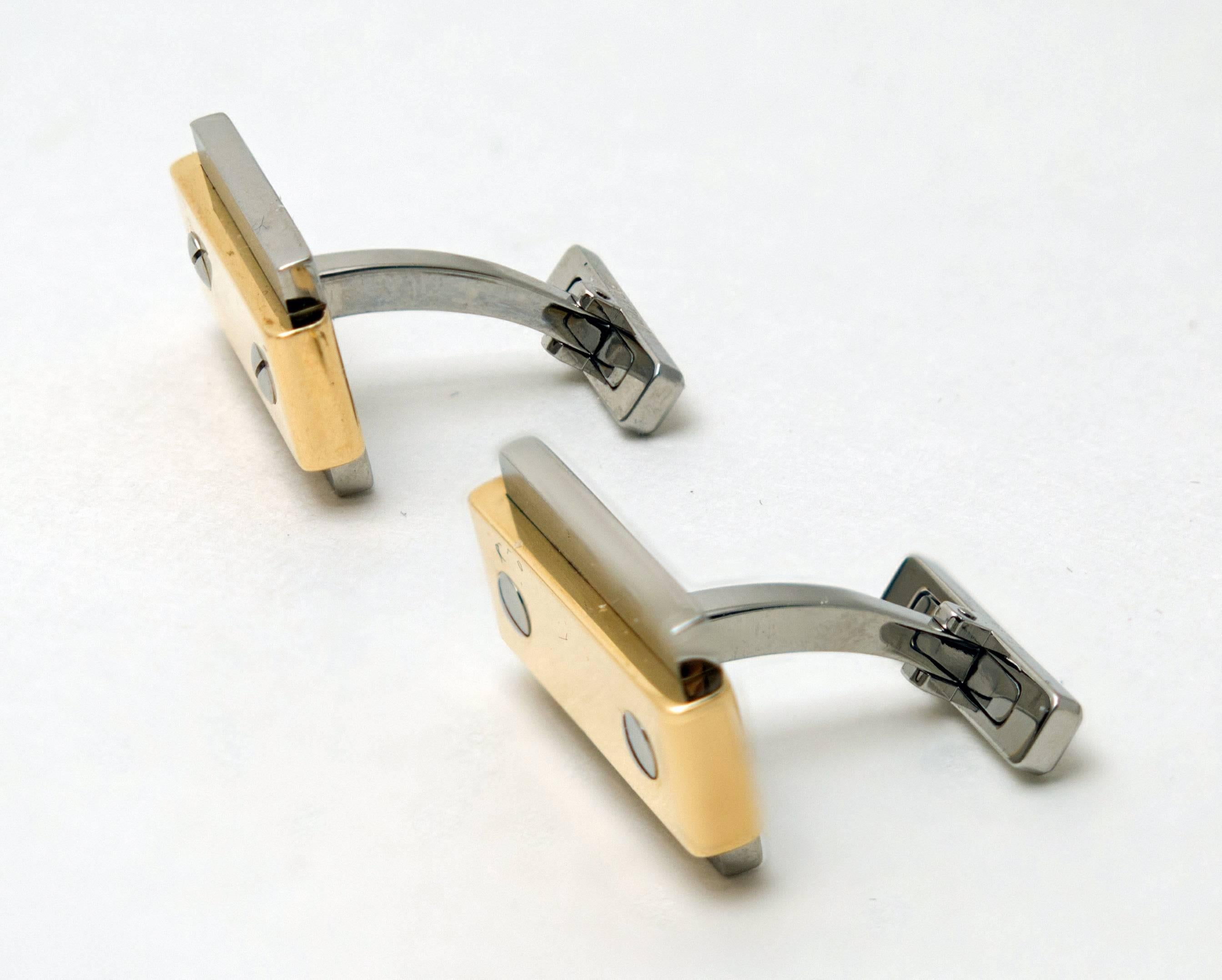 A pair of Cartier Santos cufflinks crafted in 18 K yellow gold and stainless steel / acier. The cufflinks featuring the classic Santos design, with a yellow gold band and the distinctive screws, and would be the perfect complement to the Santos
