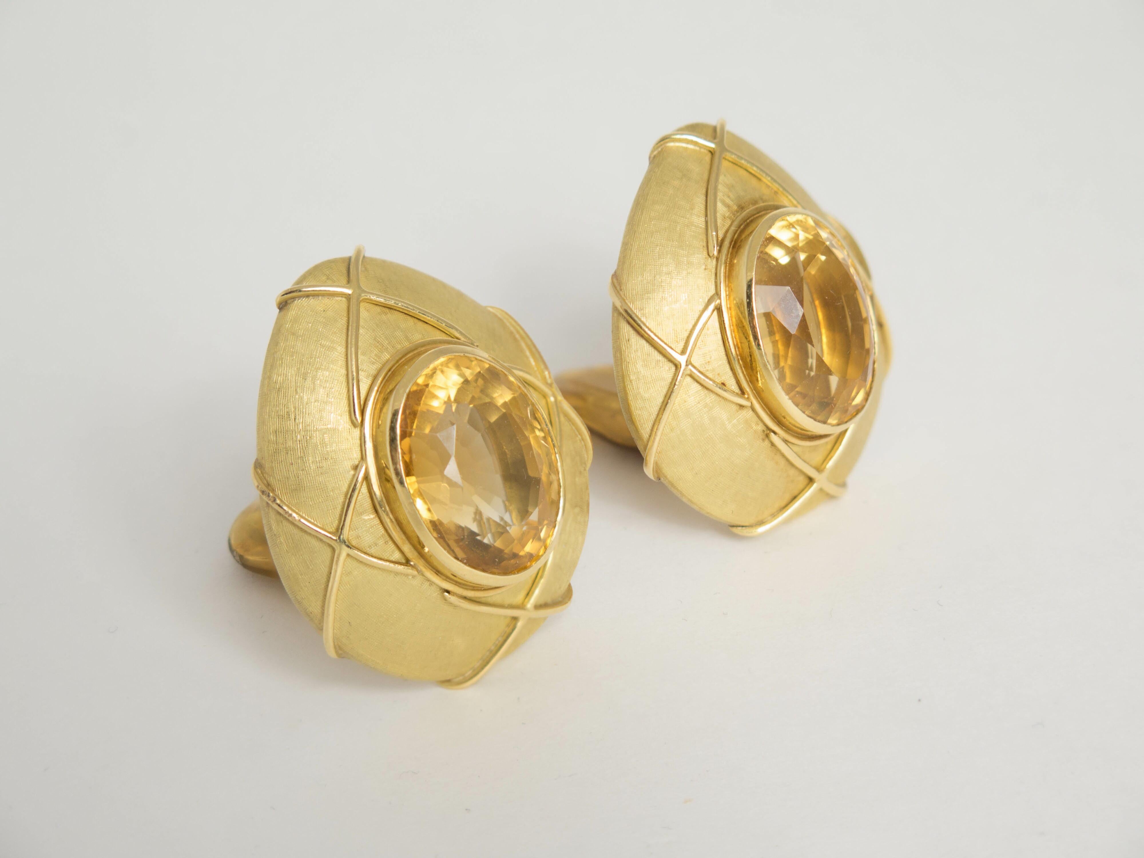 An impressive pair of large 18K yellow brushed gold clip earrings. Each earring centered with a large faceted oval citrine (total weight of both stones 29 carats).  
Concealed pendant hooks. Measured 1.35