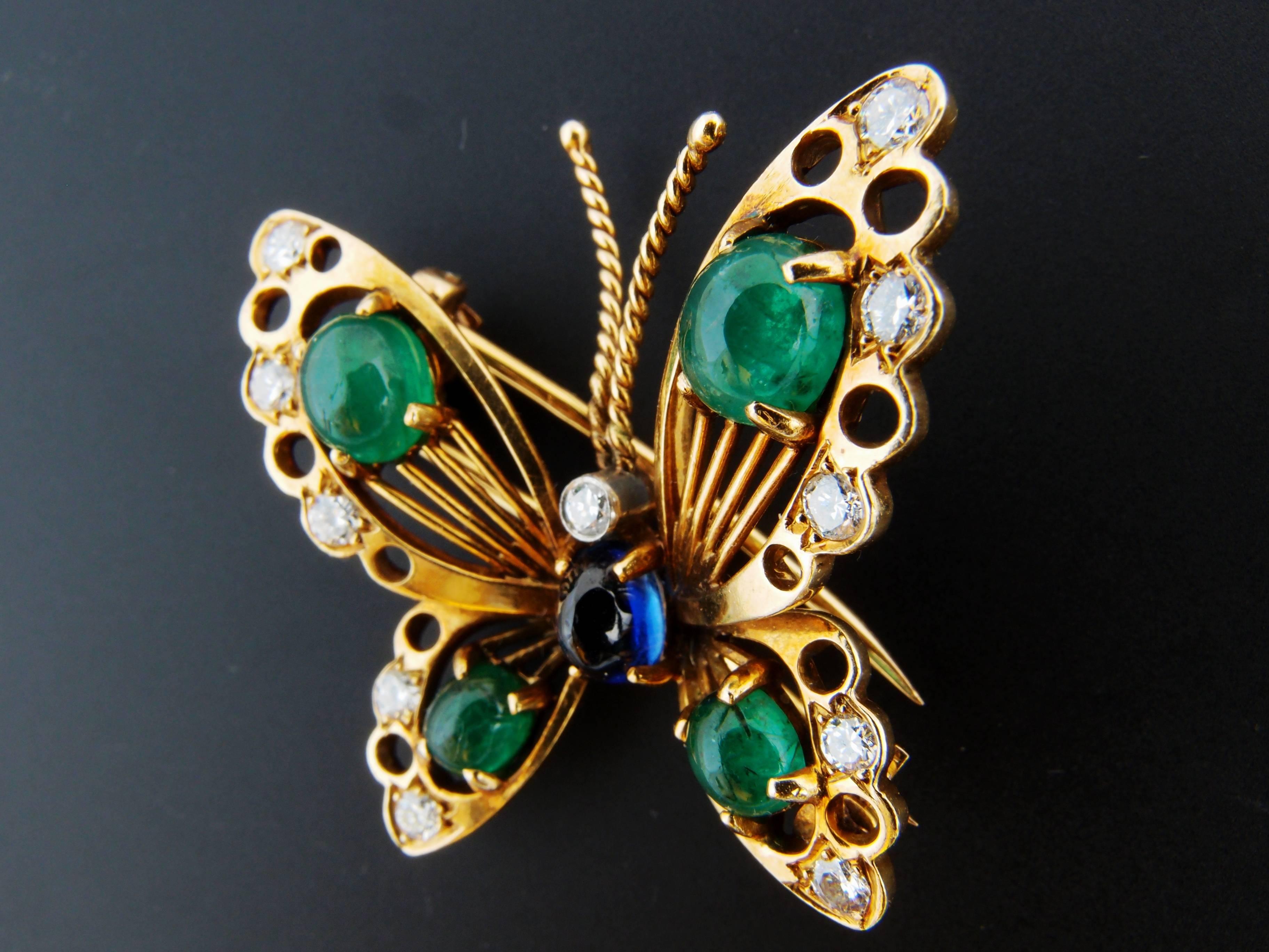 Beautiful 18 k gold hand fabricated brooch in the shape of a butterfly with one  cabochon natural blue sapphire corundum weight approximately 1 carat, four oval cabochon emerald beryls total weight 2.45 carats, 11 diamonds total weight approximately