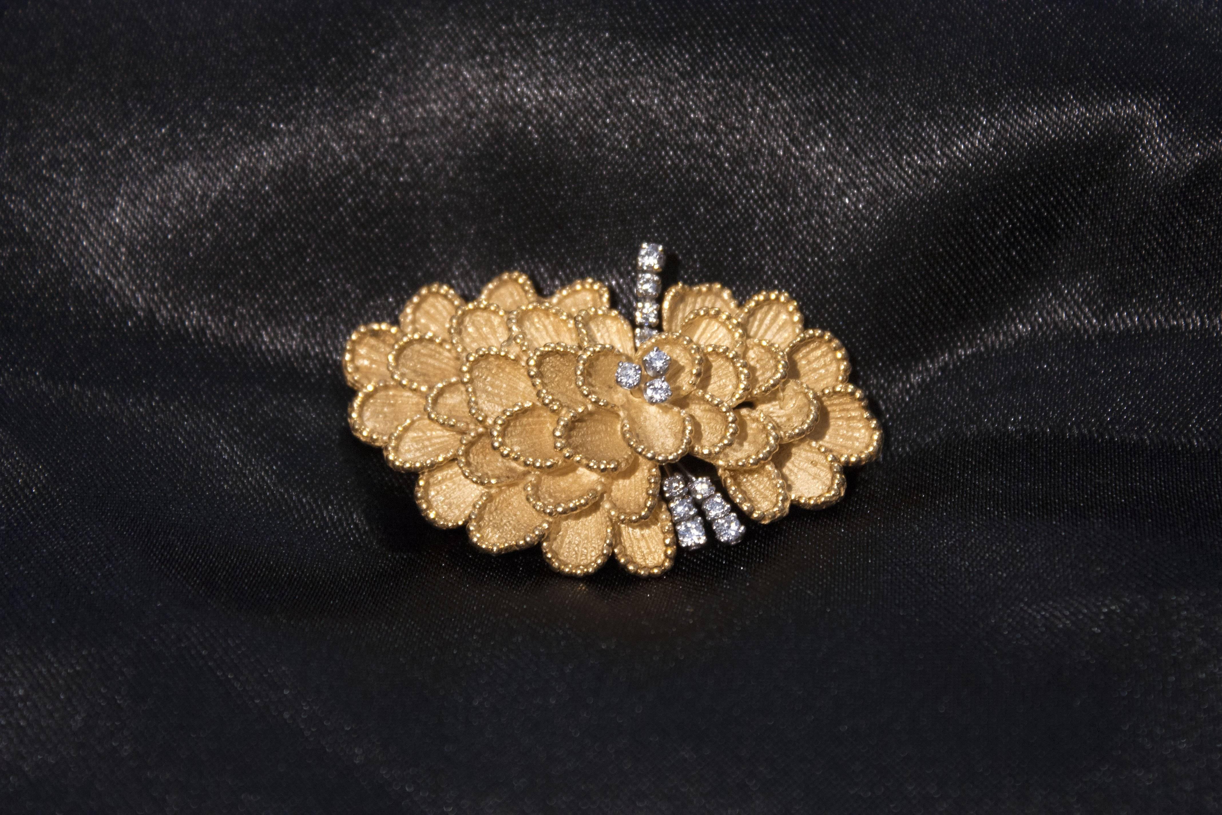 Beautiful circa 1960's 18 K gold and diamond floral brooch. Bead works all along each of the petal. With maker mark 