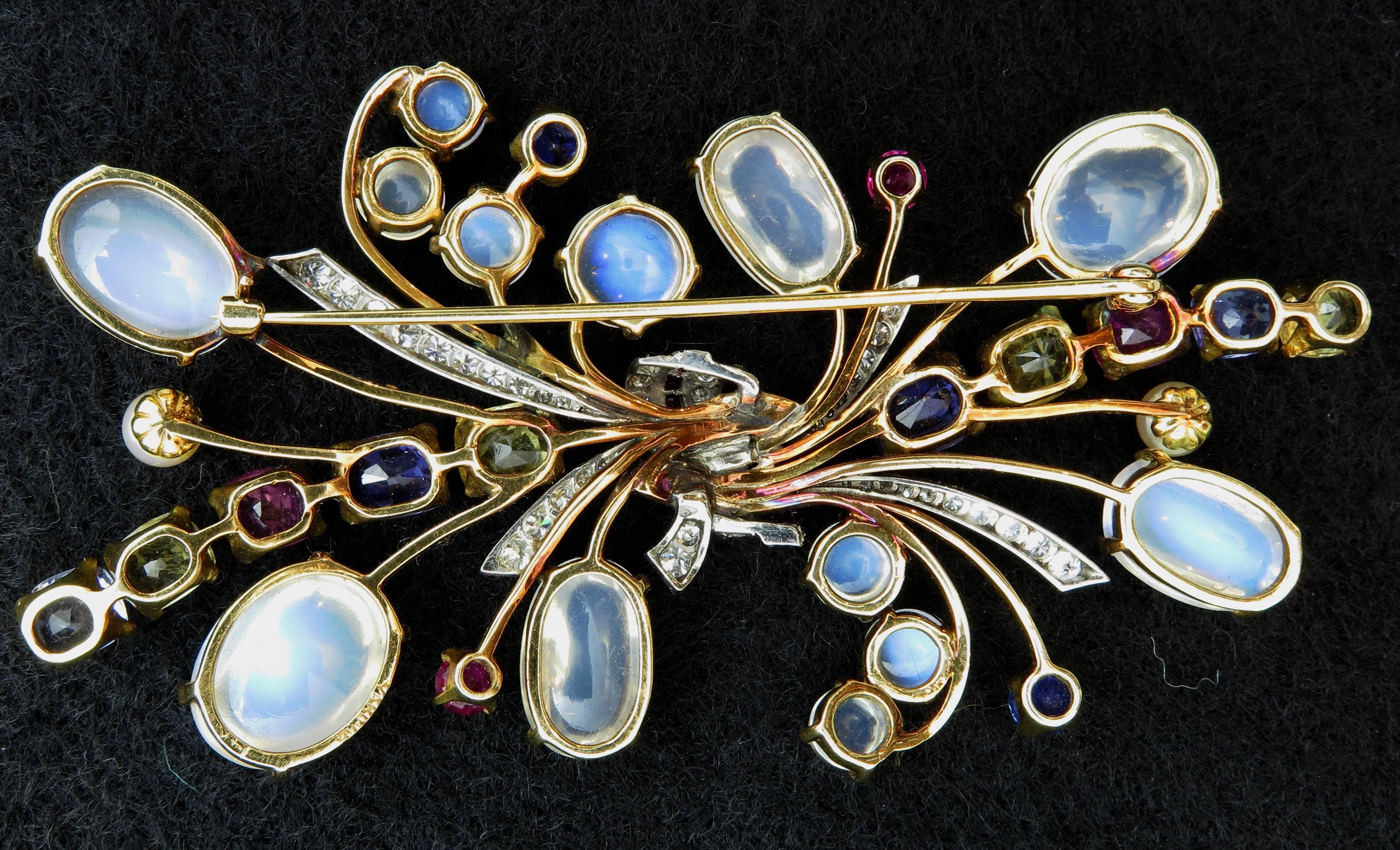 A large and beautiful hand crafted yellow and white 14K gold brooch with total approximately 45 carats of moonstones, 14 carats of sapphires, 1.04 carats of rubies, 1.1 carats of diamonds and 2 culture pearls.

The moonstones are transparent white