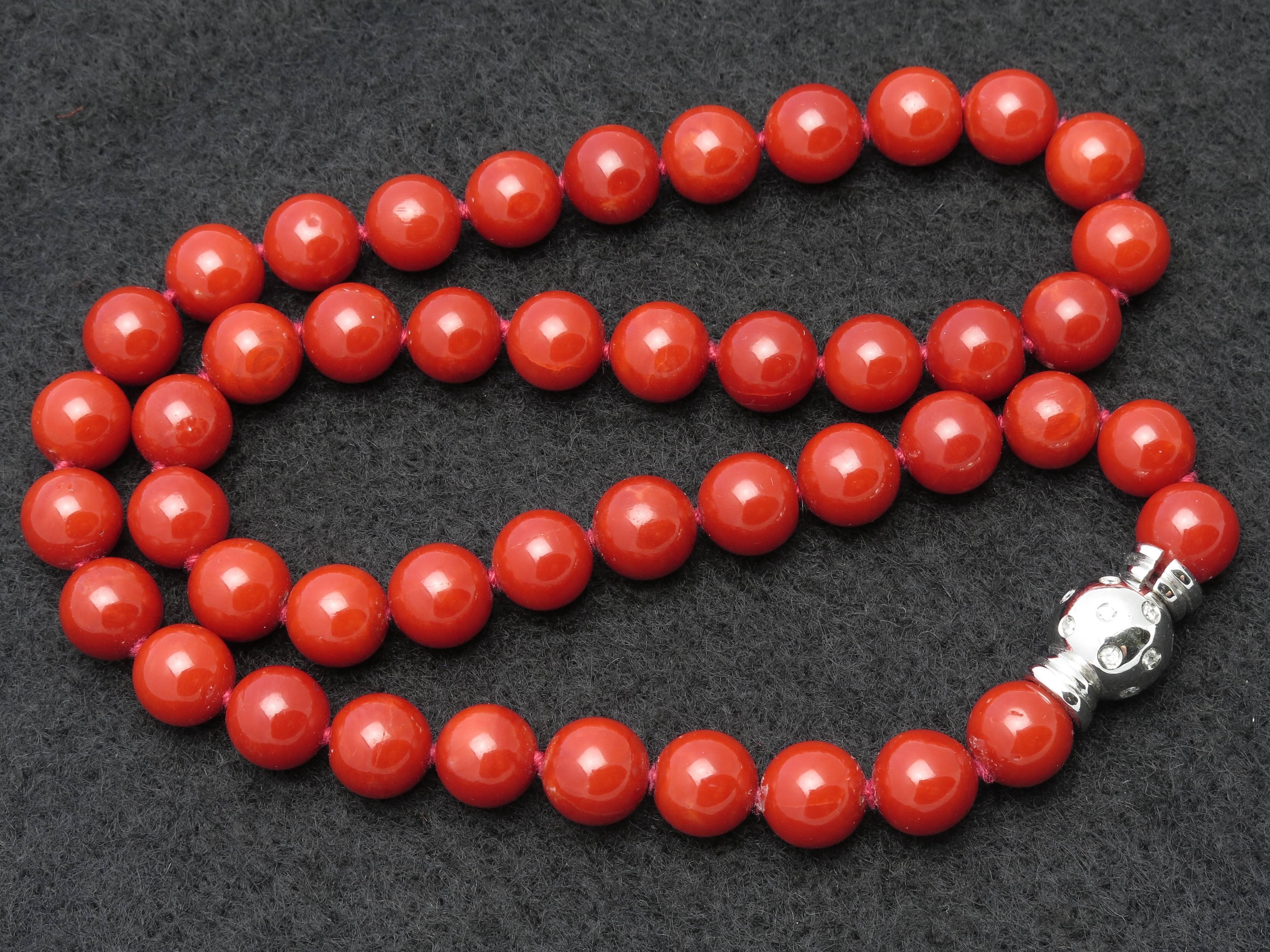 An impeccable necklace of natural Mediterranean coral (GIA certified), featuring 46 well matched beads (all approximately 9mm) of uniform deep orange red color, secured by an 18k white gold and diamond clasp. 
Beads range from 9.06 mm - 8.74mm in