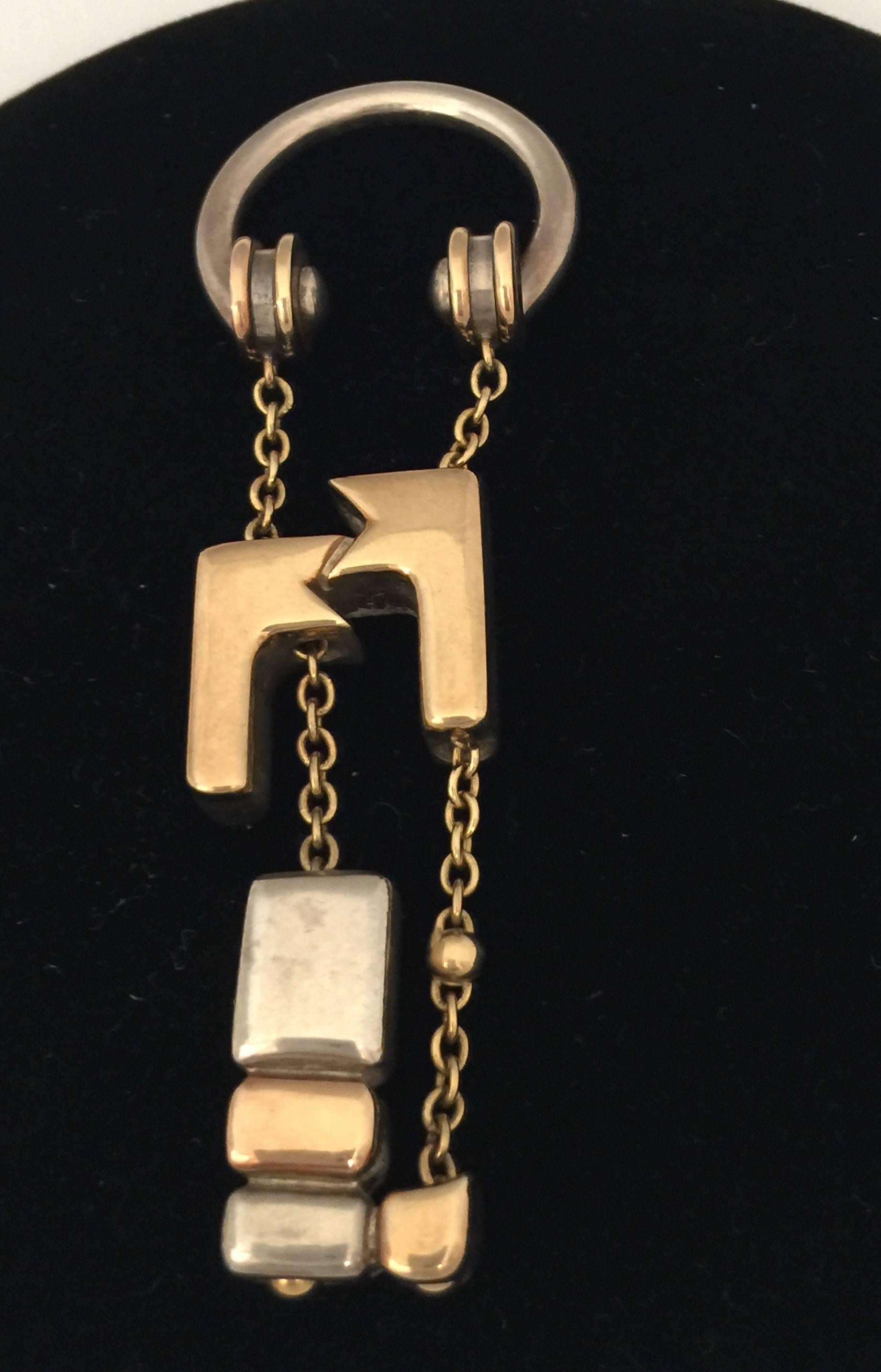 A superb, highly sculptural cubist keyring composed of an abstracted intertwined double panther fob - the facing heads of 18k gold, the intertwining bodies of gold and silver -  suspended by a gold chain from a sterling sliver horseshoe screw ring
