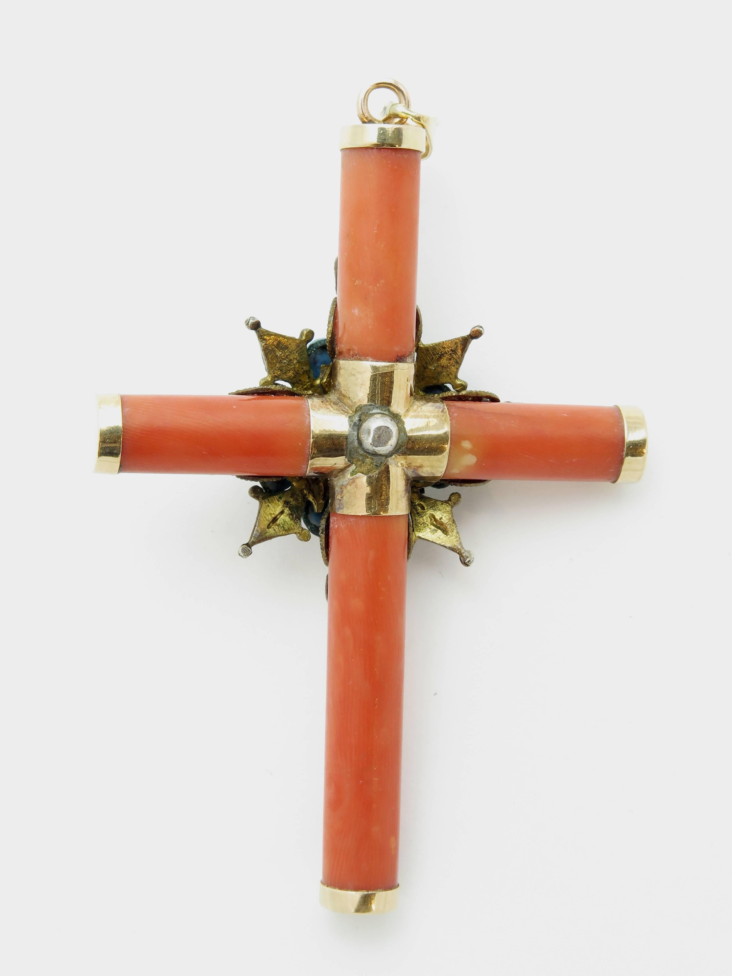 A stunning coral cross formed by tubular reddish-organge pieces of coral, capped with 14k gold mounts. Overlaid with an intricate silver filigree rosette embellished with turquoise, rubies and pearls.
