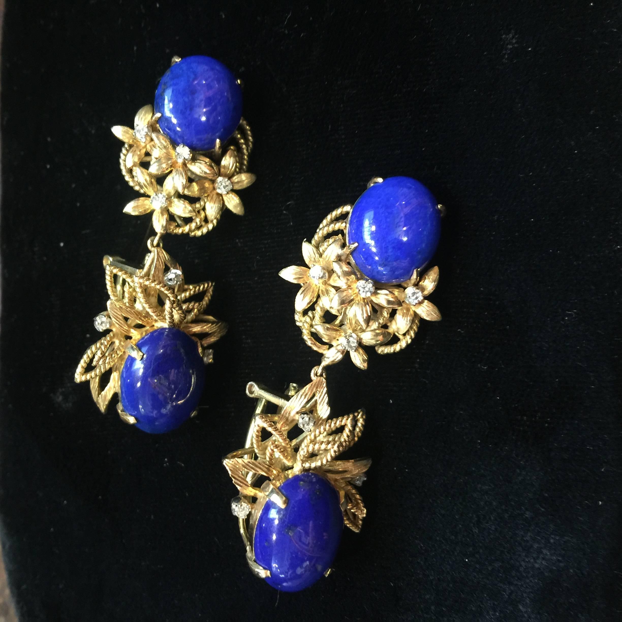Beautiful pair of dangling earrings. Each set with 2 cabochon oval shape lapis lazuli and 7 round brilliant cut diamonds. 14K yellow gold with twisted rope and floral designs. Clip back.  marked 14K. 2